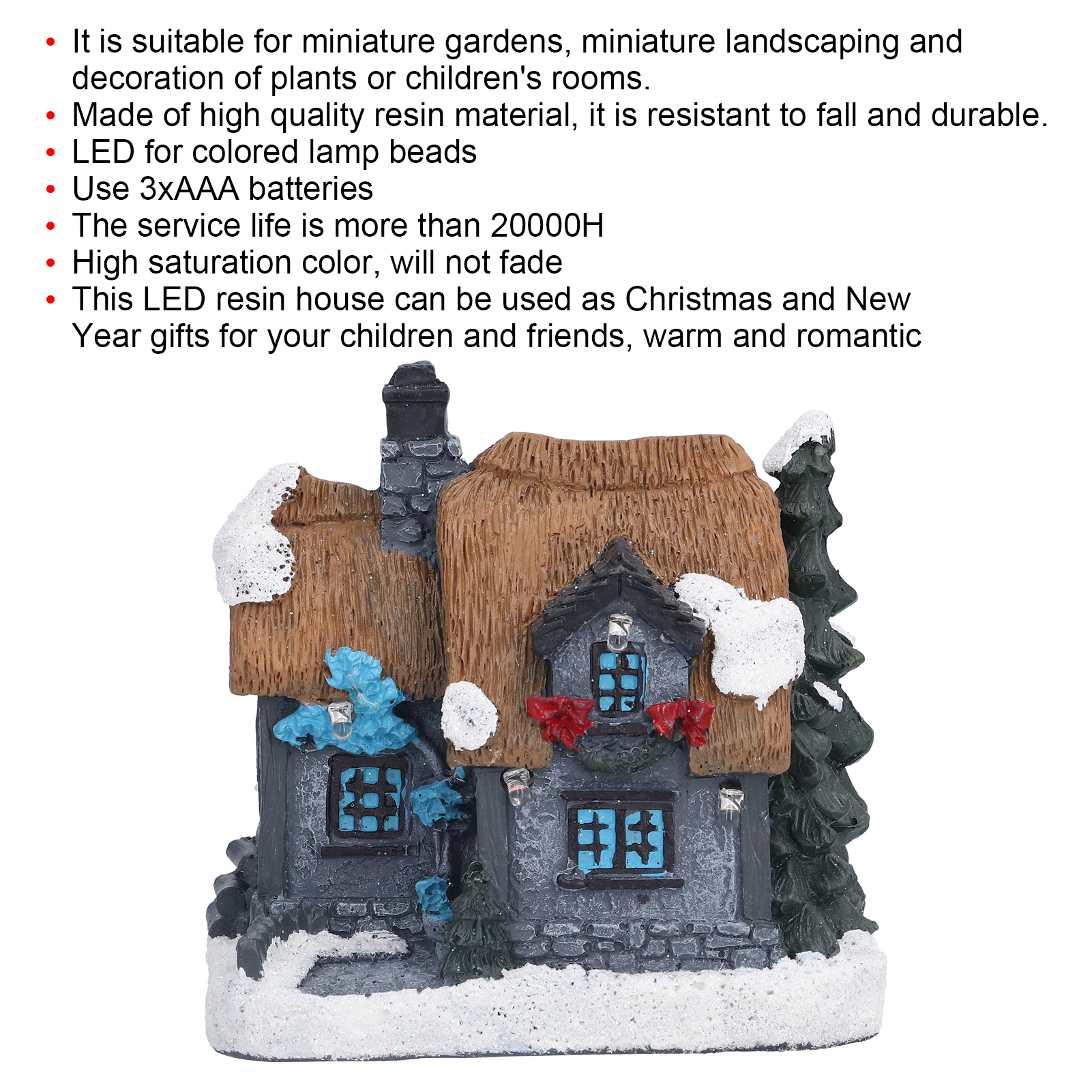Miniatur-Resinhaus mit Schnee, Strohdach und Weihnachtsdekorationen. Ein kleiner Baum steht daneben. Weißer Hintergrund.
