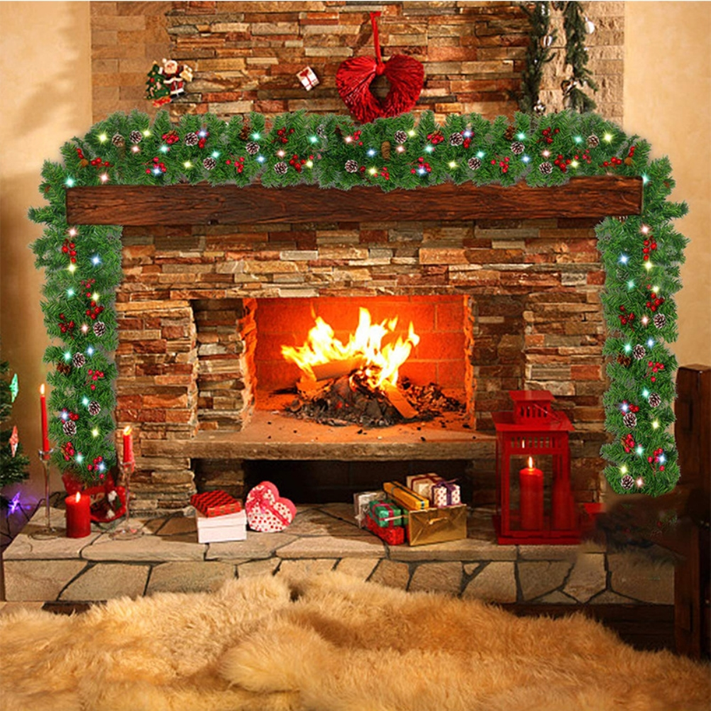 Ein Kamin mit brennendem Feuer, geschmückt mit einer grünen Girlande und Weihnachtsschmuck. Geschenke und Kerzen sind davor.