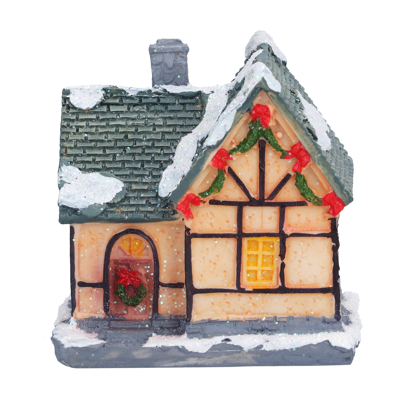 Eine kleine Hausfigur mit Schnee auf dem Dach. Es hat ein grünes Dach, cremefarbene Wände und Weihnachtsdekorationen.