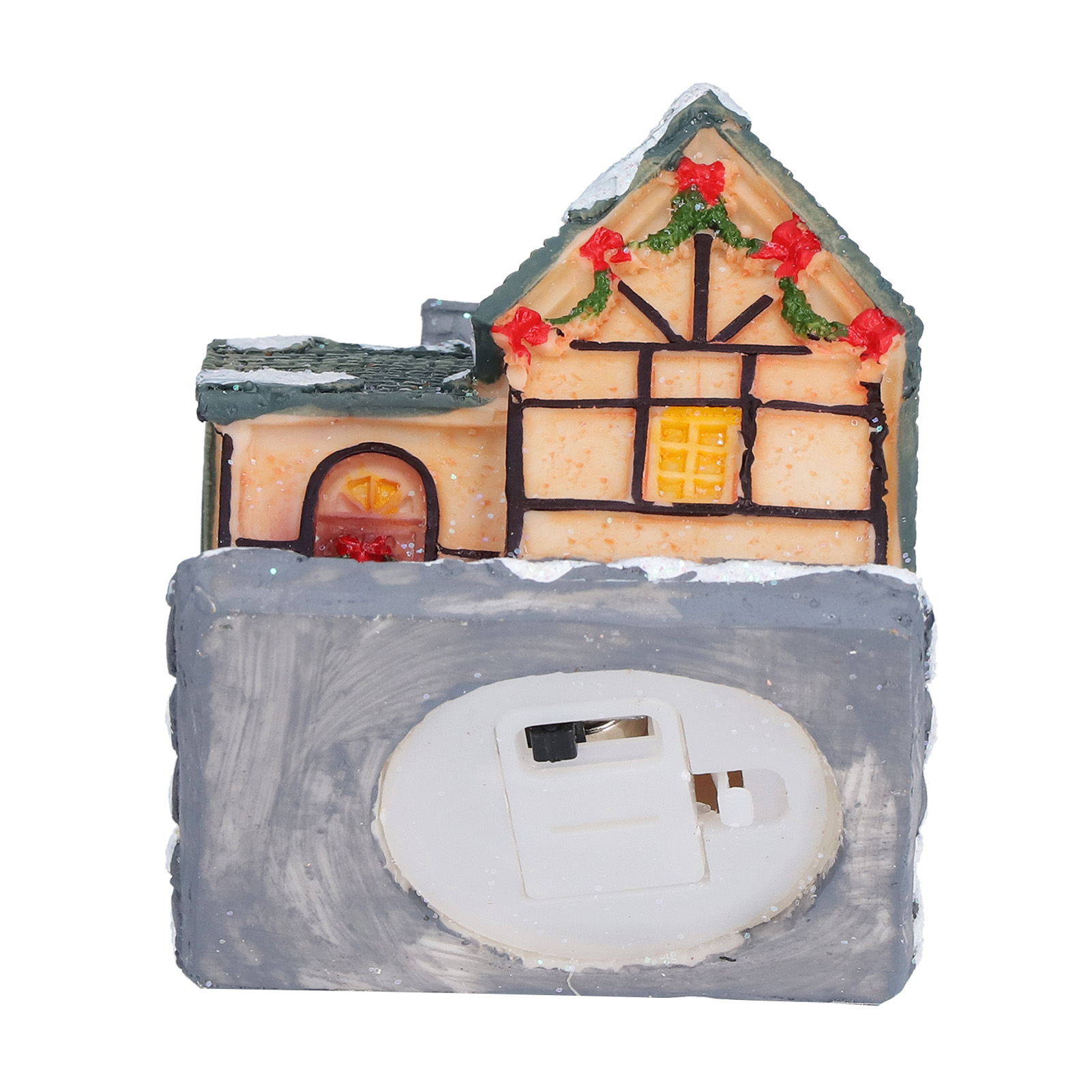Ein Miniatur-Weihnachtshaus mit schneebedecktem Dach und gelbem Fenster. Rote Schleifen schmücken die Spitze. Die Basis hat ein Batteriefach.