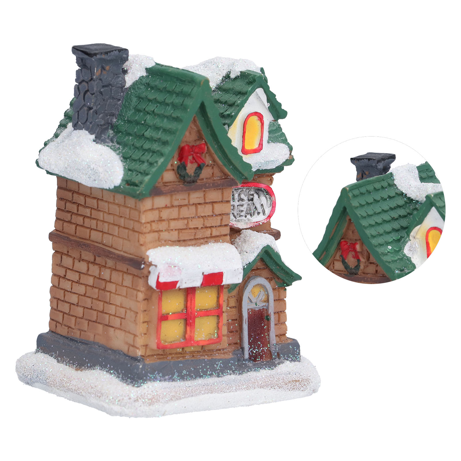 Ein weihnachtliches Miniaturhaus mit Schornstein, Schnee, grünem Dach und roten Schleifendekorationen.