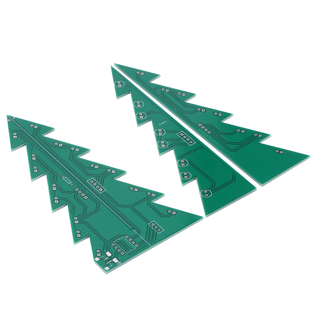 Drei grüne Leiterplatten in Form von Weihnachtsbäumen liegen auf einer weißen Oberfläche. Jede hat komplizierte elektronische Pfade und Komponenten.