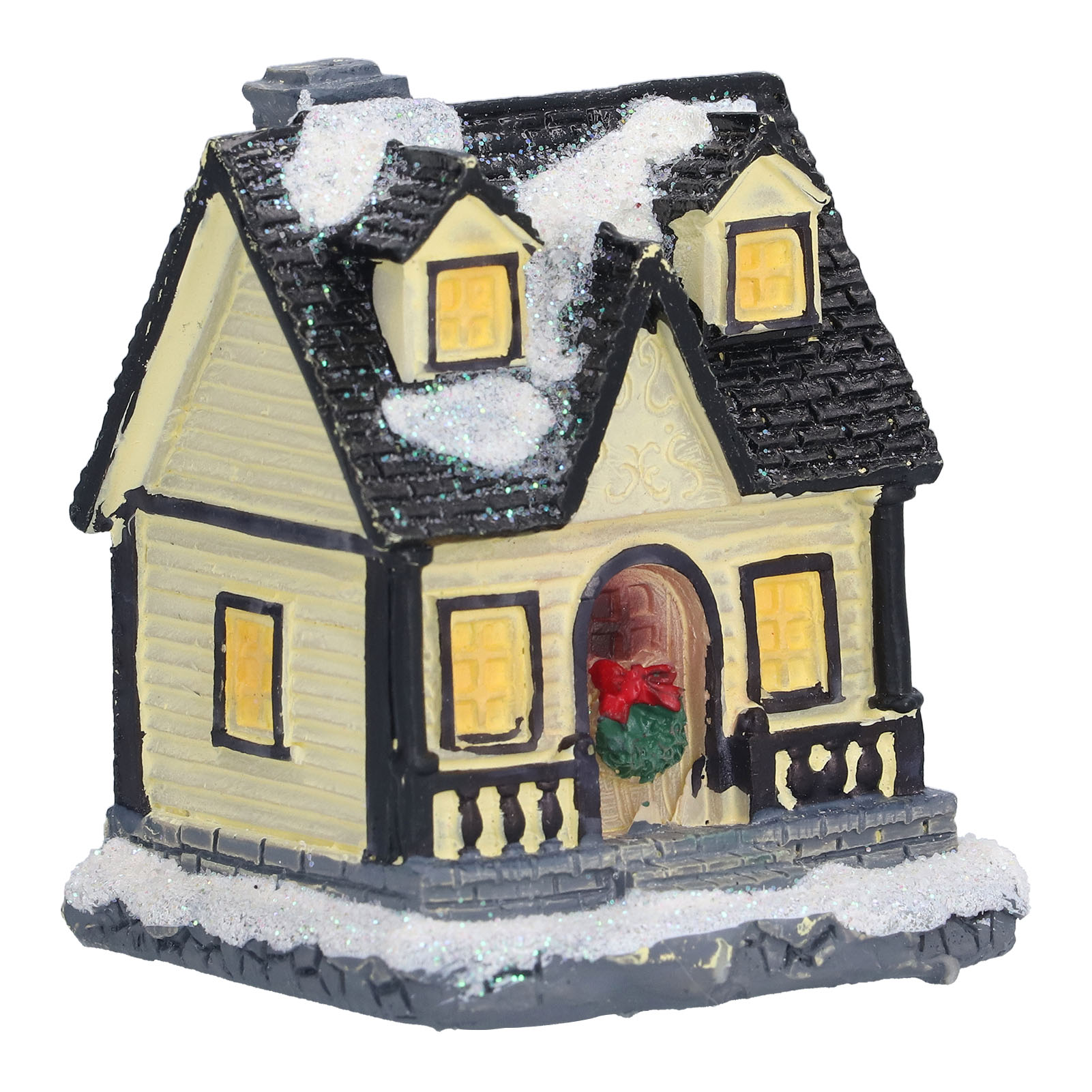 Ein Miniaturhaus mit schwarzem Dach, Schnee und einem Weihnachtskranz an der Tür. Die Fenster sind beleuchtet.