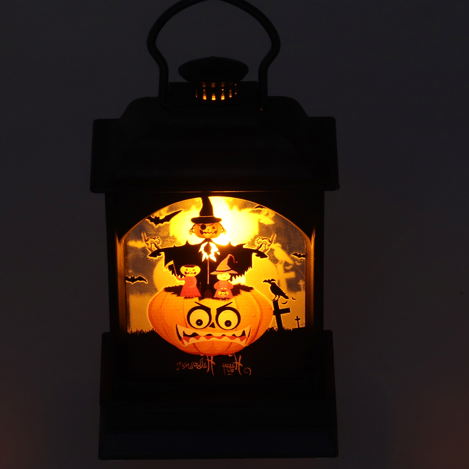 Halloween-Laterne mit Kürbis, Vogelscheuche, Fledermäusen und zwei Figuren. Sie hat einen schwarzen Rahmen und Griff mit leuchtendem Hintergrund.