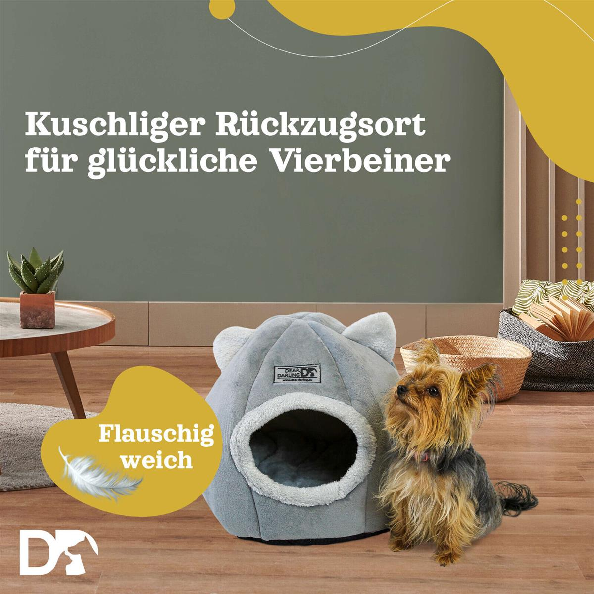Ein kleiner Hund sitzt neben einem grauen Haustierbett. Das Bett hat ohrenähnliche Formen. Text: 'Gemütlicher Rückzugsort für glückliche Haustiere'.