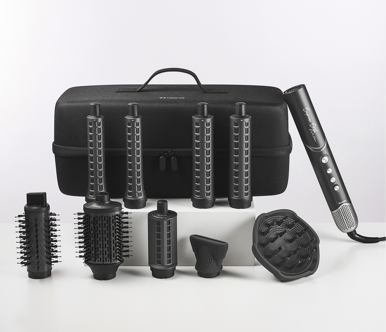 Un set nero per lo styling dei capelli con accessori, un asciugacapelli e una custodia, su sfondo bianco.