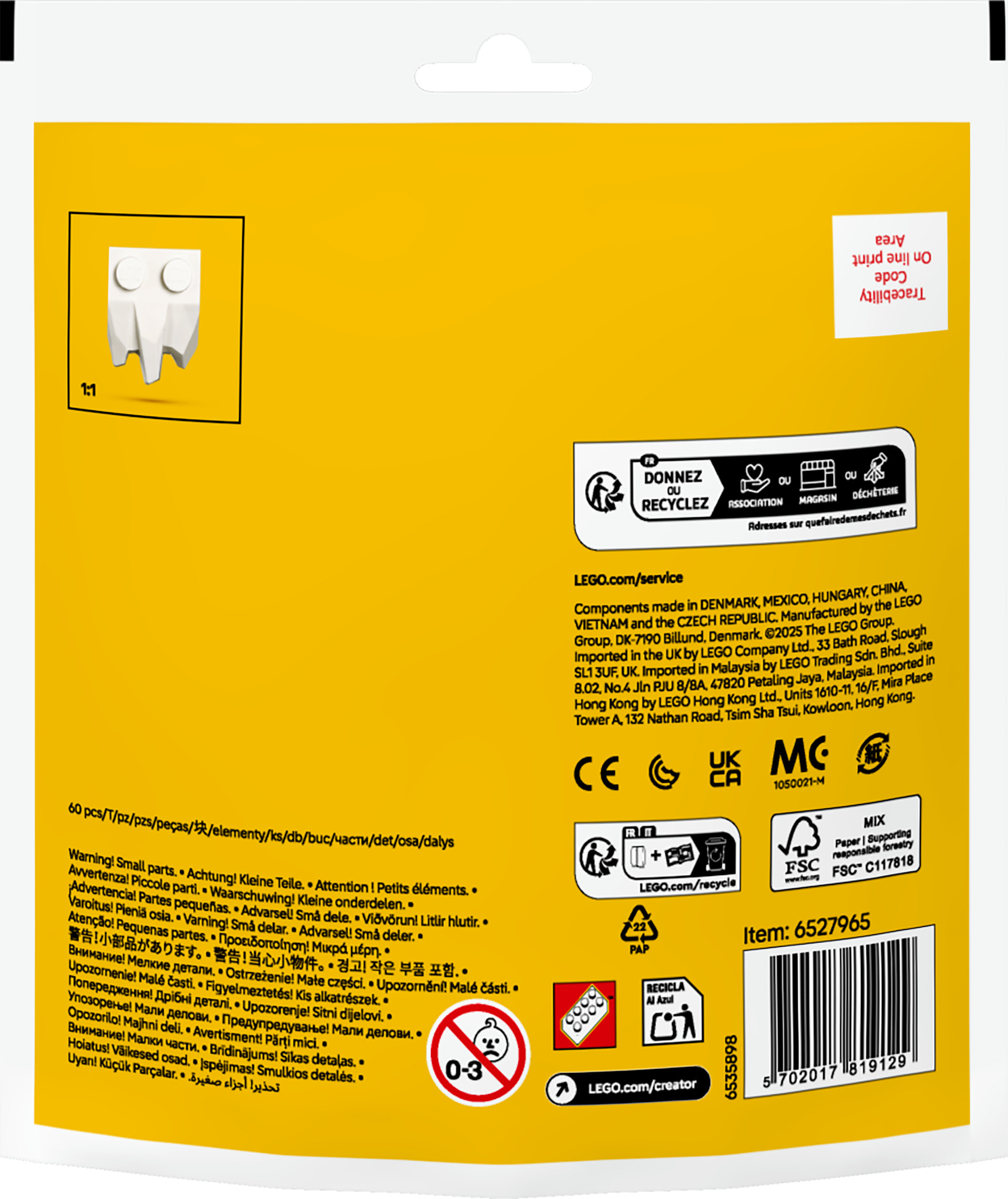 Biała figurka ducha Lego na opakowaniu Lego, z żółtym tłem. Opakowanie zawiera tekst i logo.