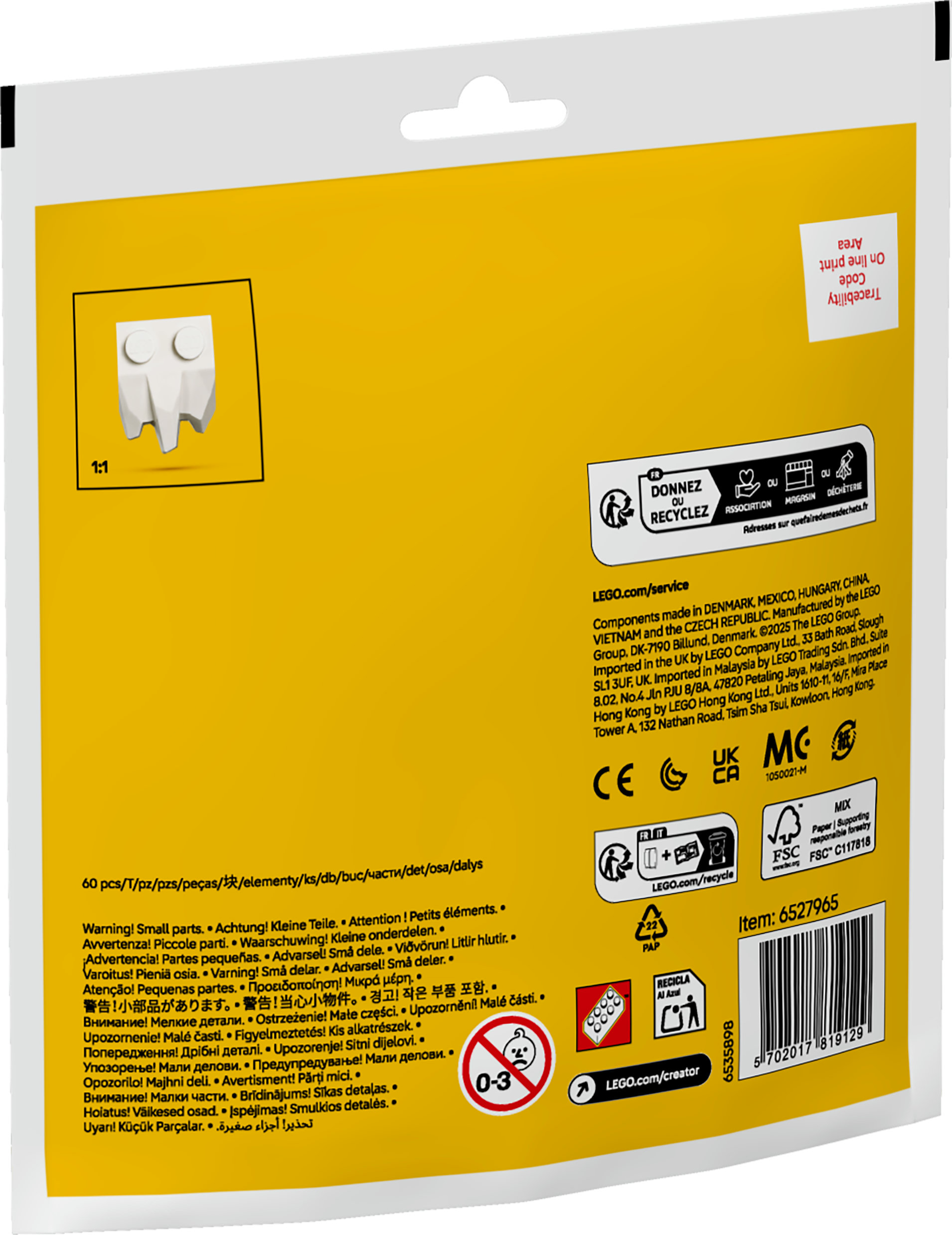 Białe pudełko LEGO z białą głową LEGO. Żółte tło z tekstem i ostrzeżeniami.