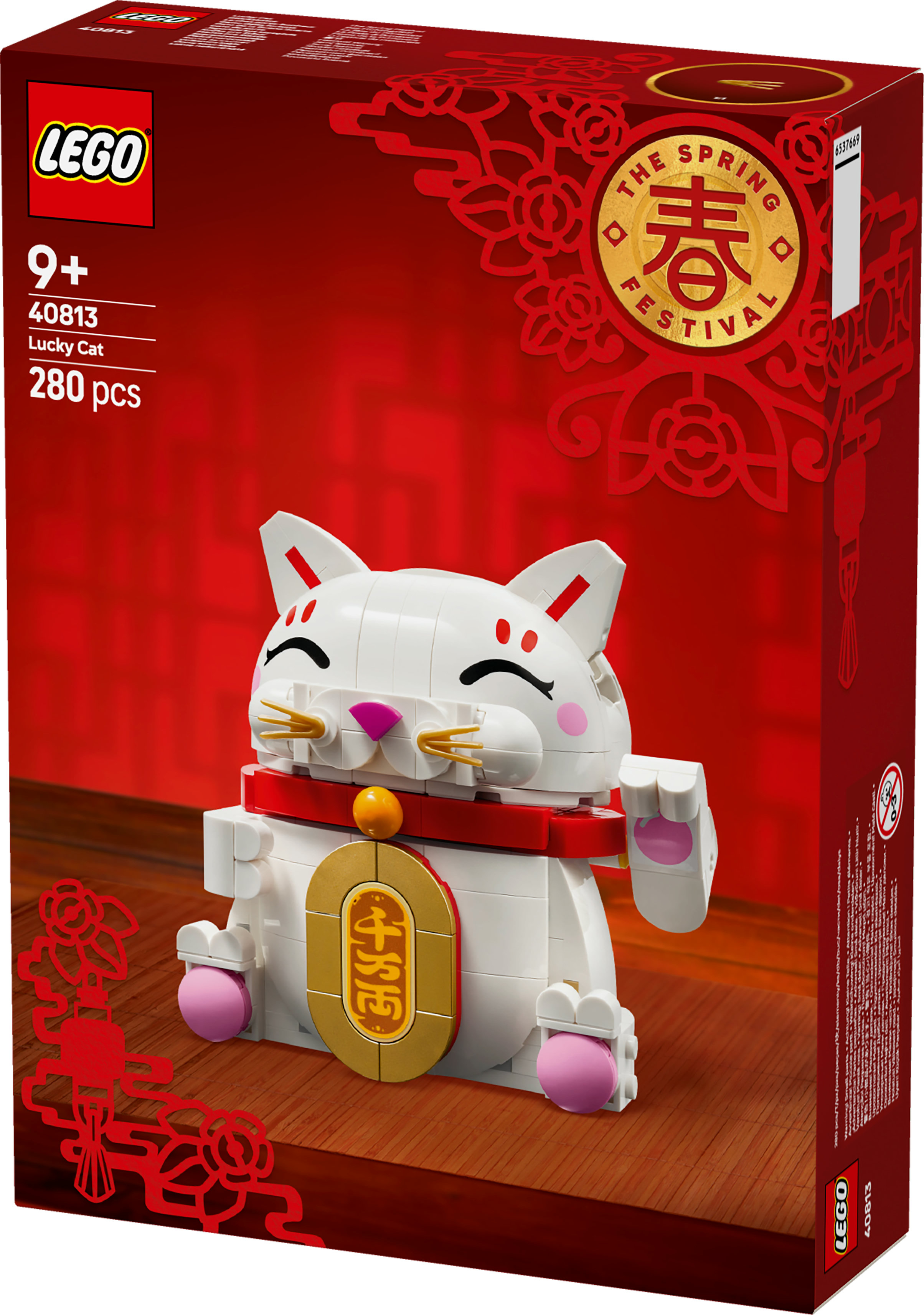Een Lego-doos toont een witte gelukskat met een rode kraag. De achtergrond is rood met Chinese nieuwjaarsversieringen.