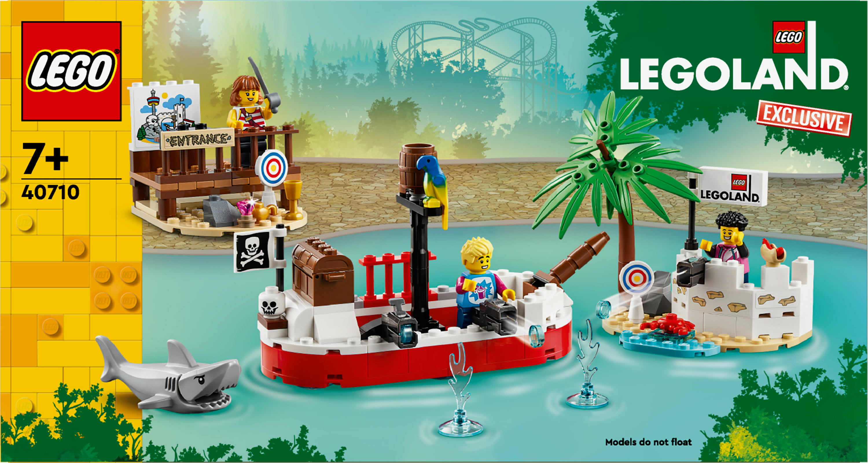Lego Legoland seti. Korsan gemisi, köpekbalığı, palmiye ağacı olan ada ve figürler içerir. Arka planda hız treni.