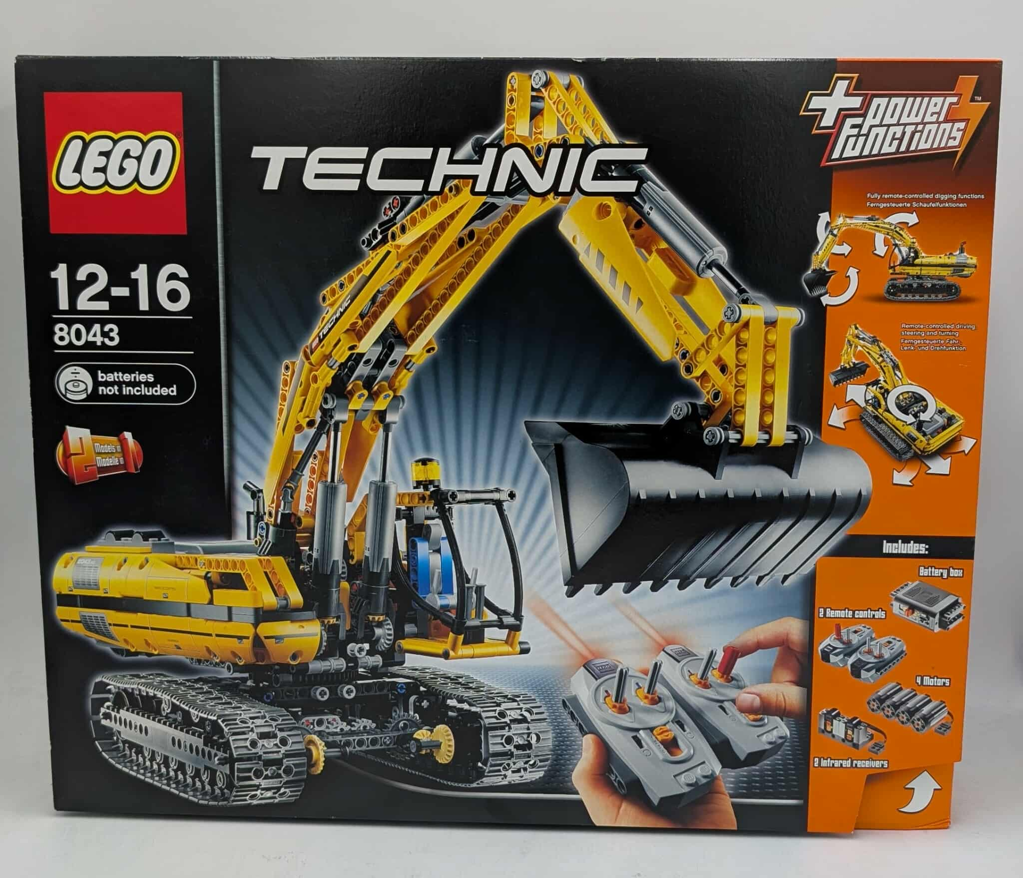 Lego Technic-doos. Een gele en zwarte graafmachine is te zien. Inclusief afstandsbedieningen, batterijbox en motoren.