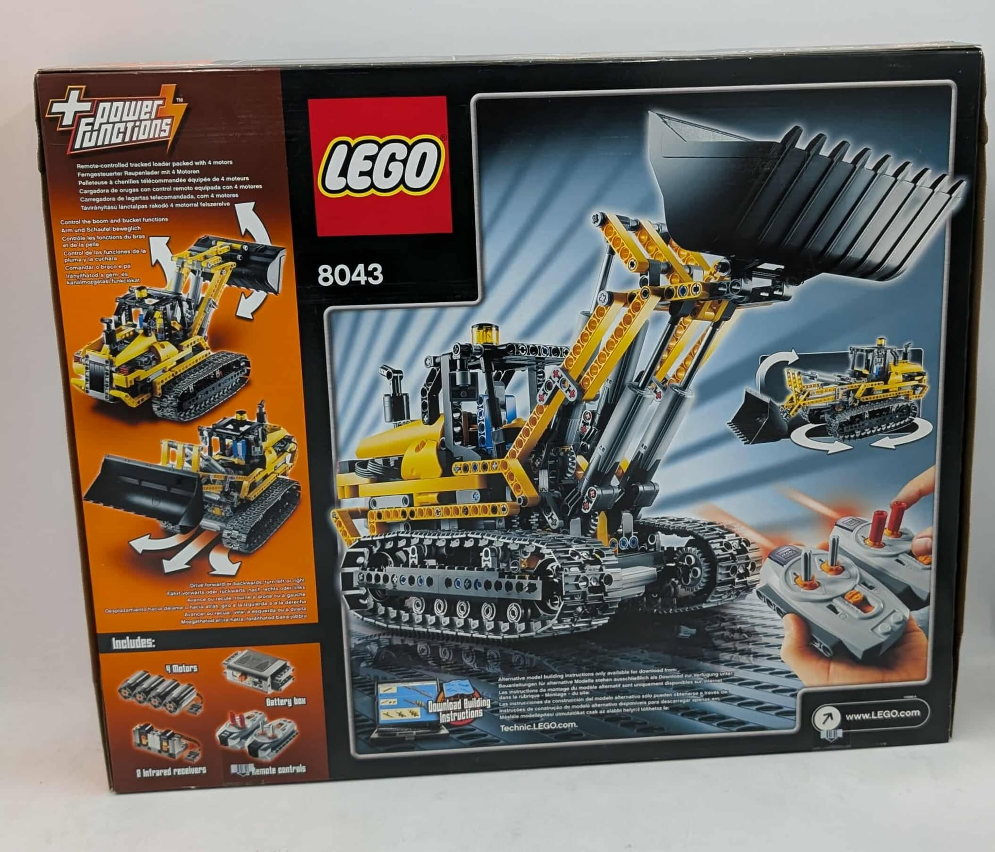 Lego-doos met een gele rupslader, afstandsbedieningen en extra onderdelen. Bevat het Lego-logo en modelnummer 8043.