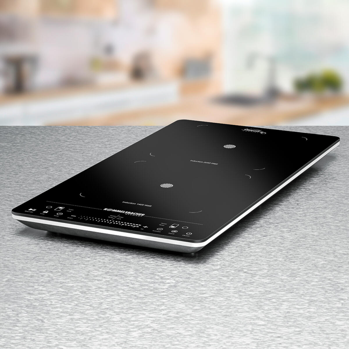 Black induction cooktop on a metallic surface. It has touch controls and the brand name is visible. The background is blurred.