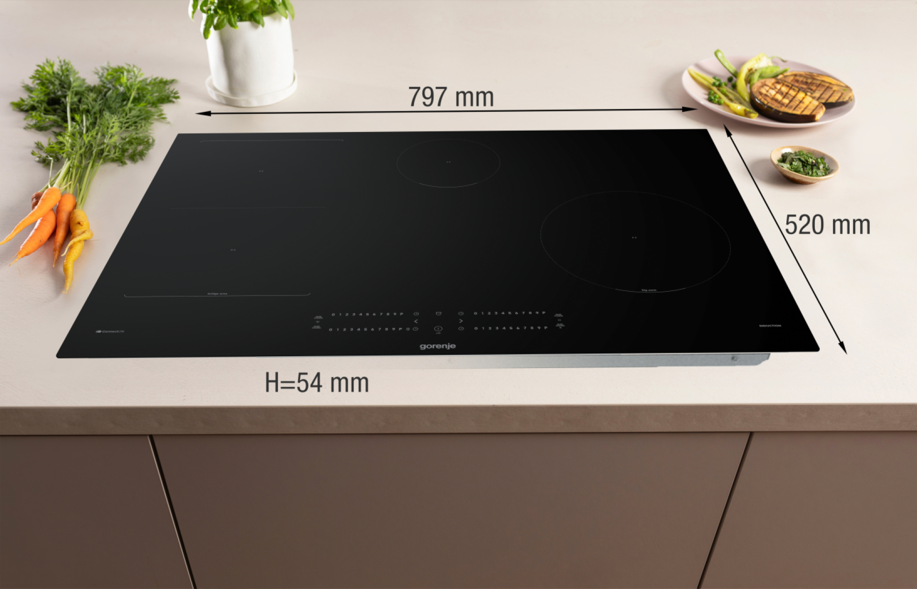 Piano cottura a induzione nero con verdure e misure. Dimensioni: 797 mm x 520 mm, altezza 54 mm. Include carote, basilico e verdure grigliate.