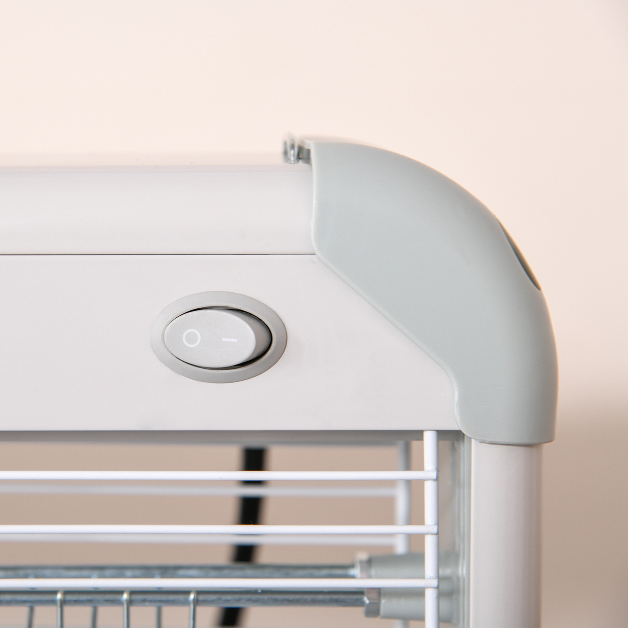 Primer plano de un dispositivo electrónico blanco con un botón de encendido gris. El fondo es de color beige claro.