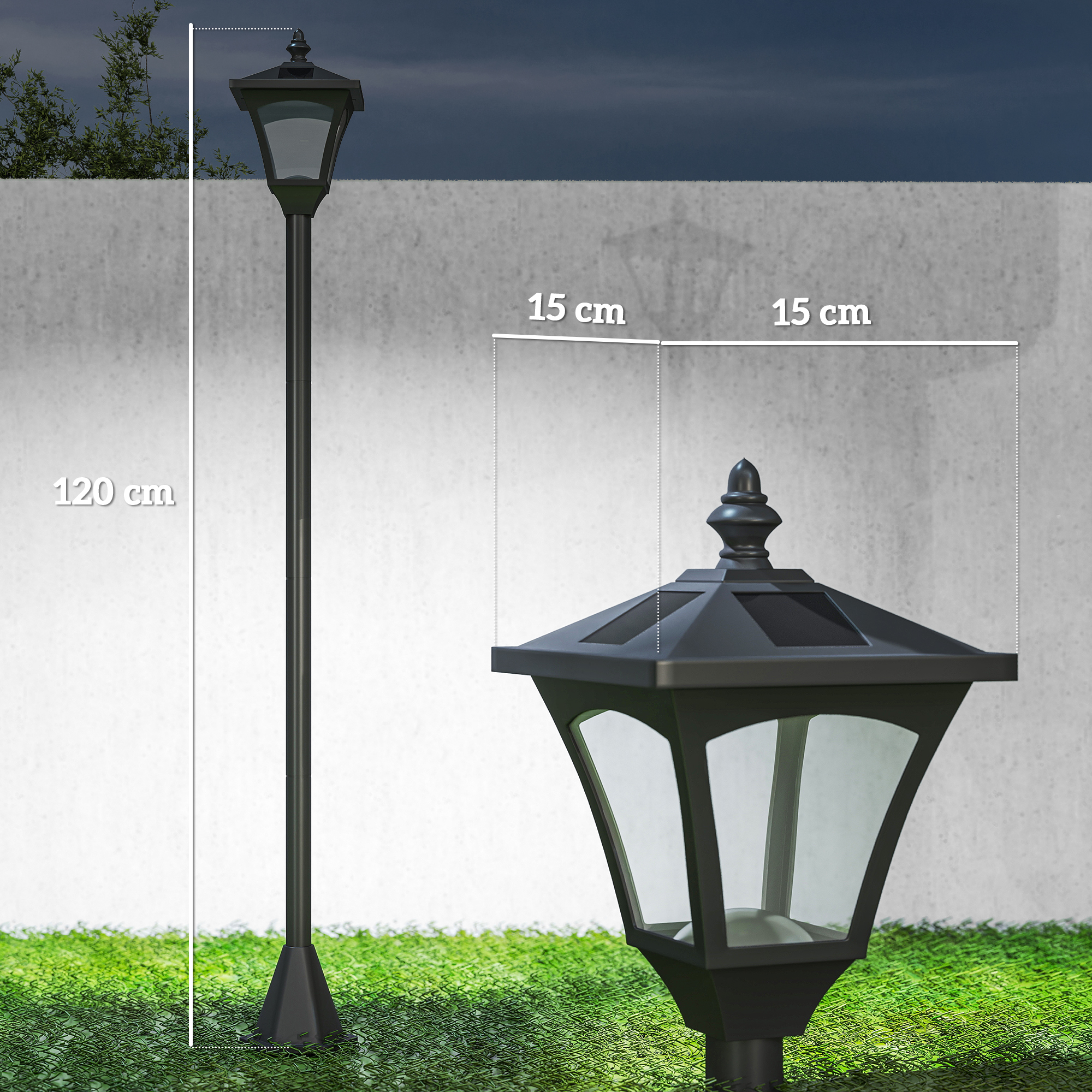 Un poste de lámpara negro con la parte superior cuadrada se alza sobre césped verde. Detrás hay una pared de concreto.