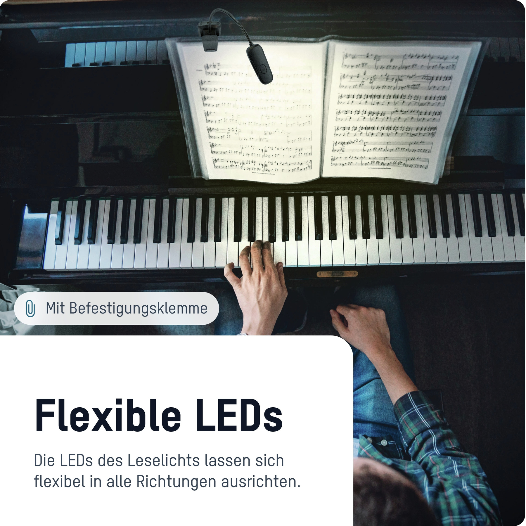 Handen die piano spelen. Bladmuziek wordt verlicht door een flexibele LED. De persoon draagt een geruit overhemd.