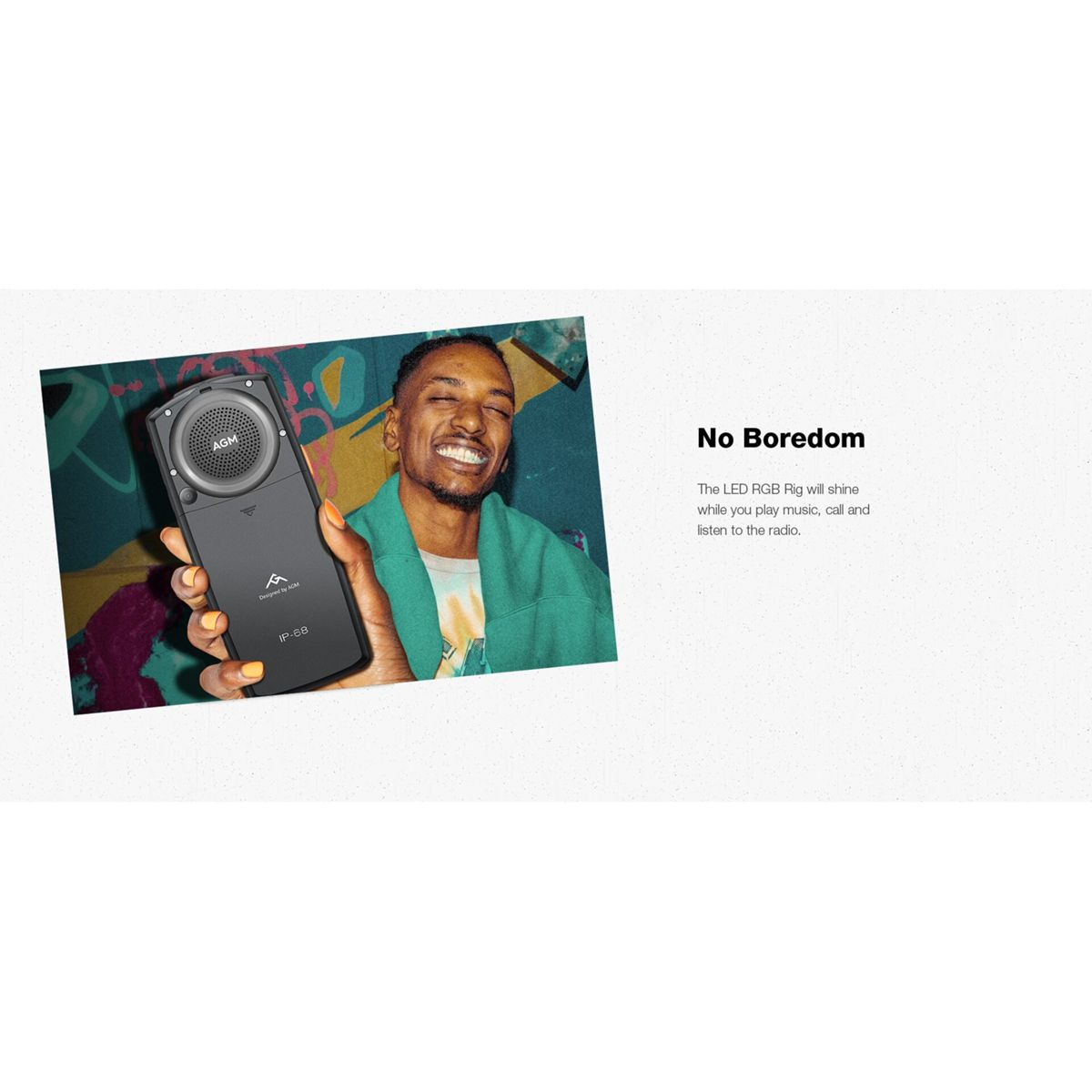 Mężczyzna uśmiecha się, trzymając czarny głośnik. Głośnik ma logo AGM. Tło to graffiti i tekst 'No Boredom'.