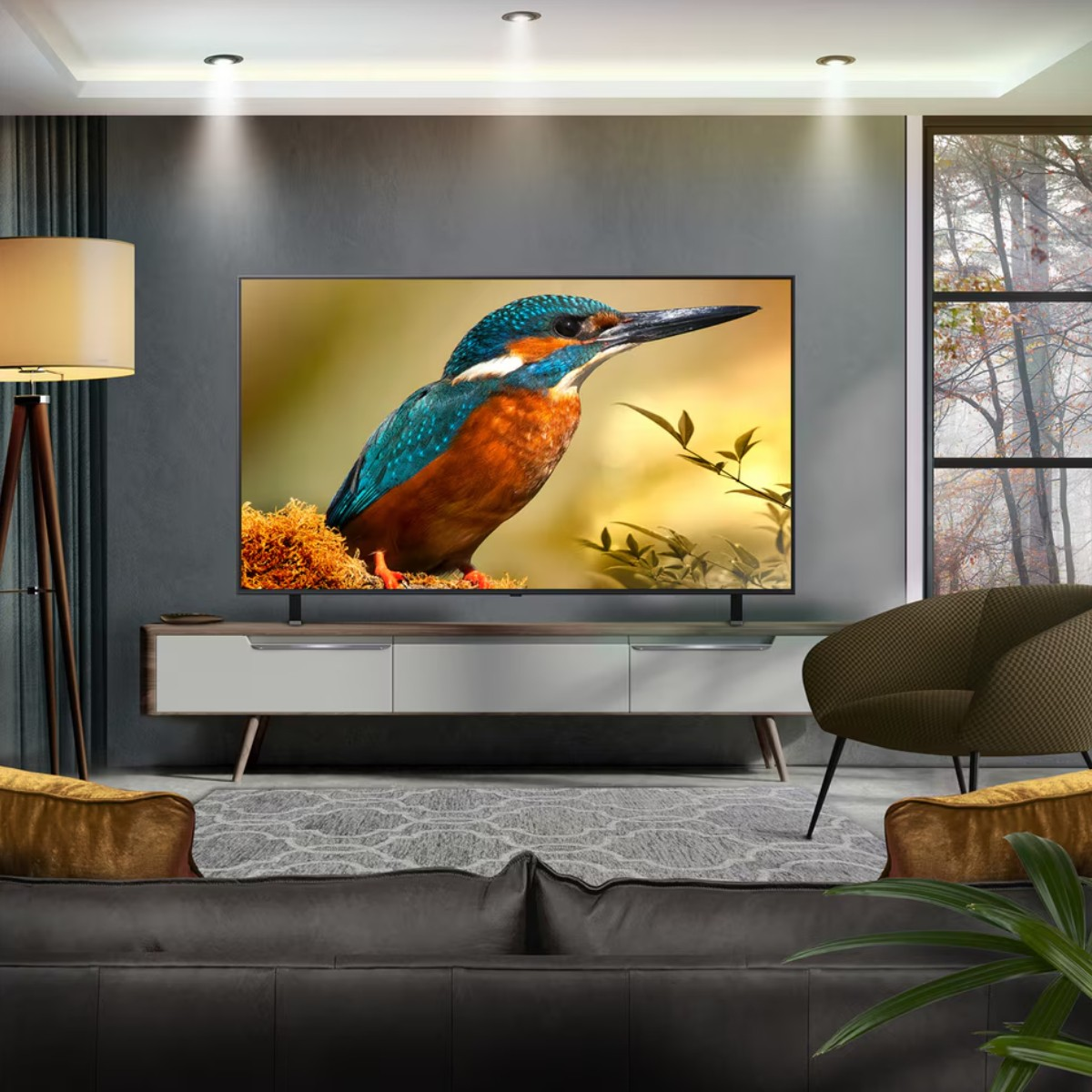 Un soggiorno con una TV che mostra un uccello. C'è un divano, una poltrona e una finestra con alberi. Una lampada illumina la scena.