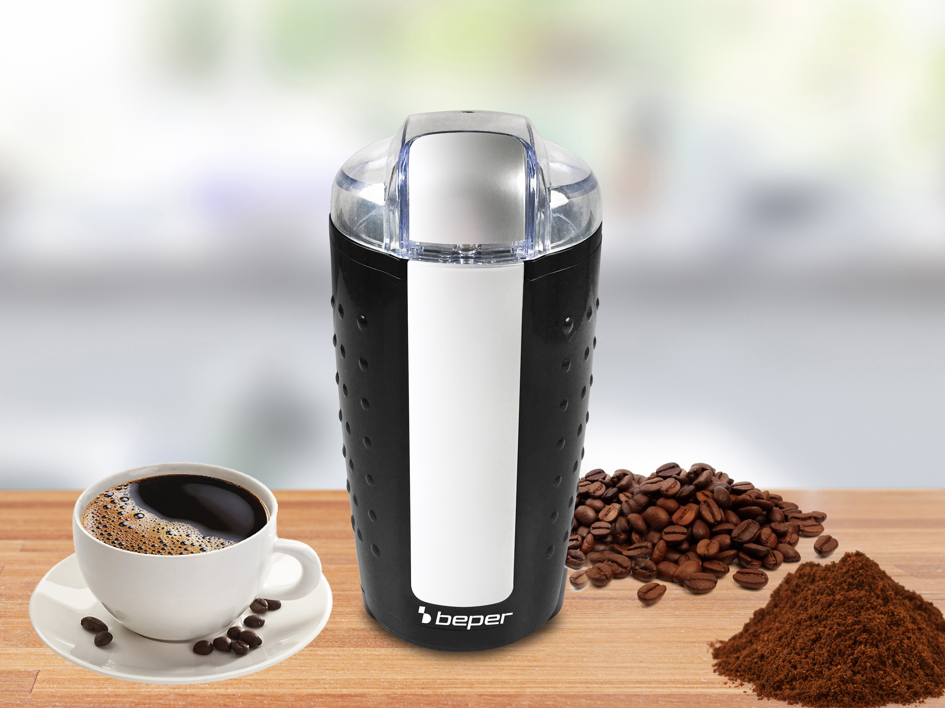 Młynek do kawy, filiżanka kawy, ziarna i mielona kawa na drewnie. Czarny młynek z białymi detalami.