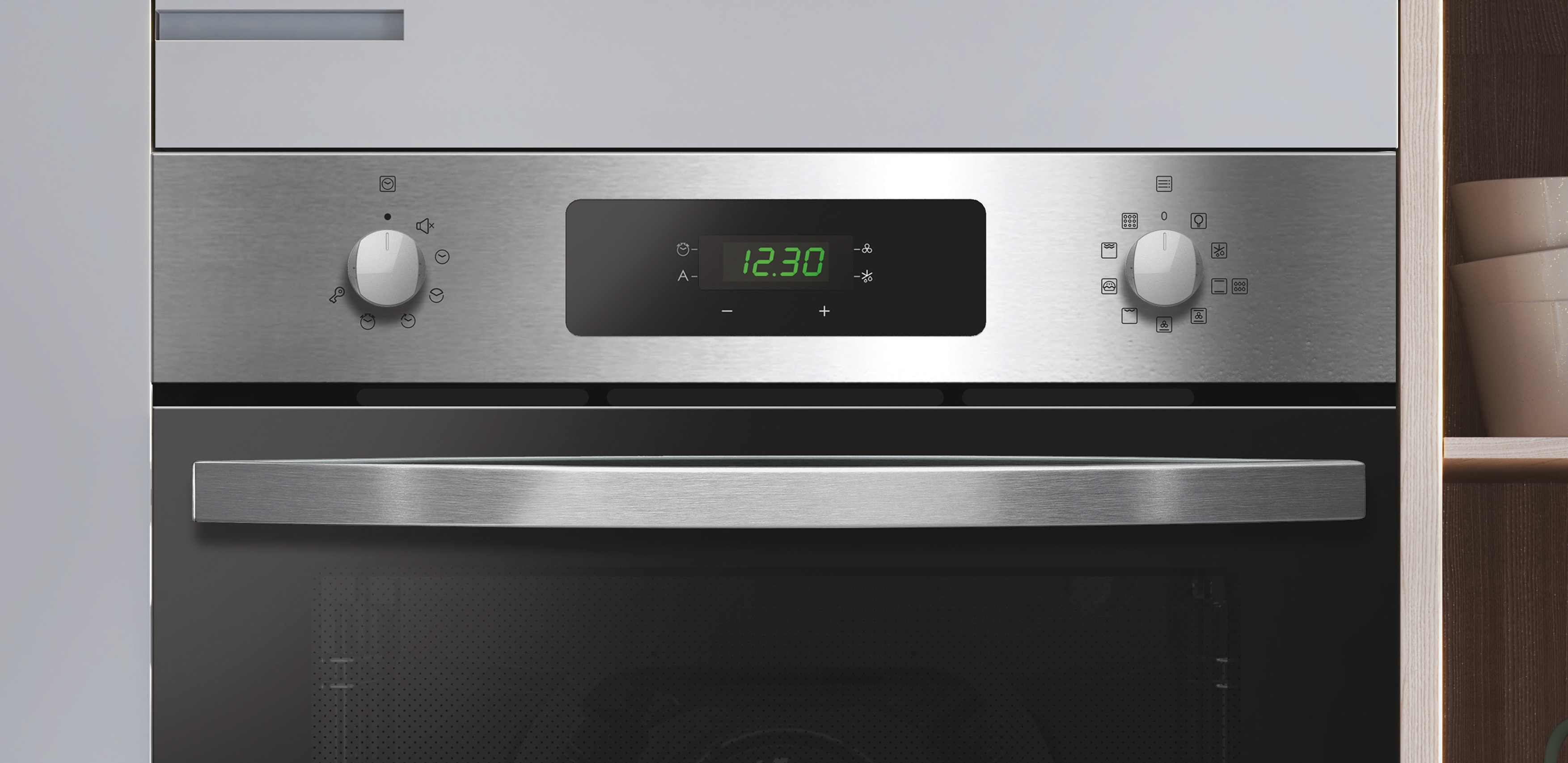 Un horno de acero inoxidable con reloj digital que muestra las 12:30. Perillas a cada lado. Un asa debajo de la puerta.