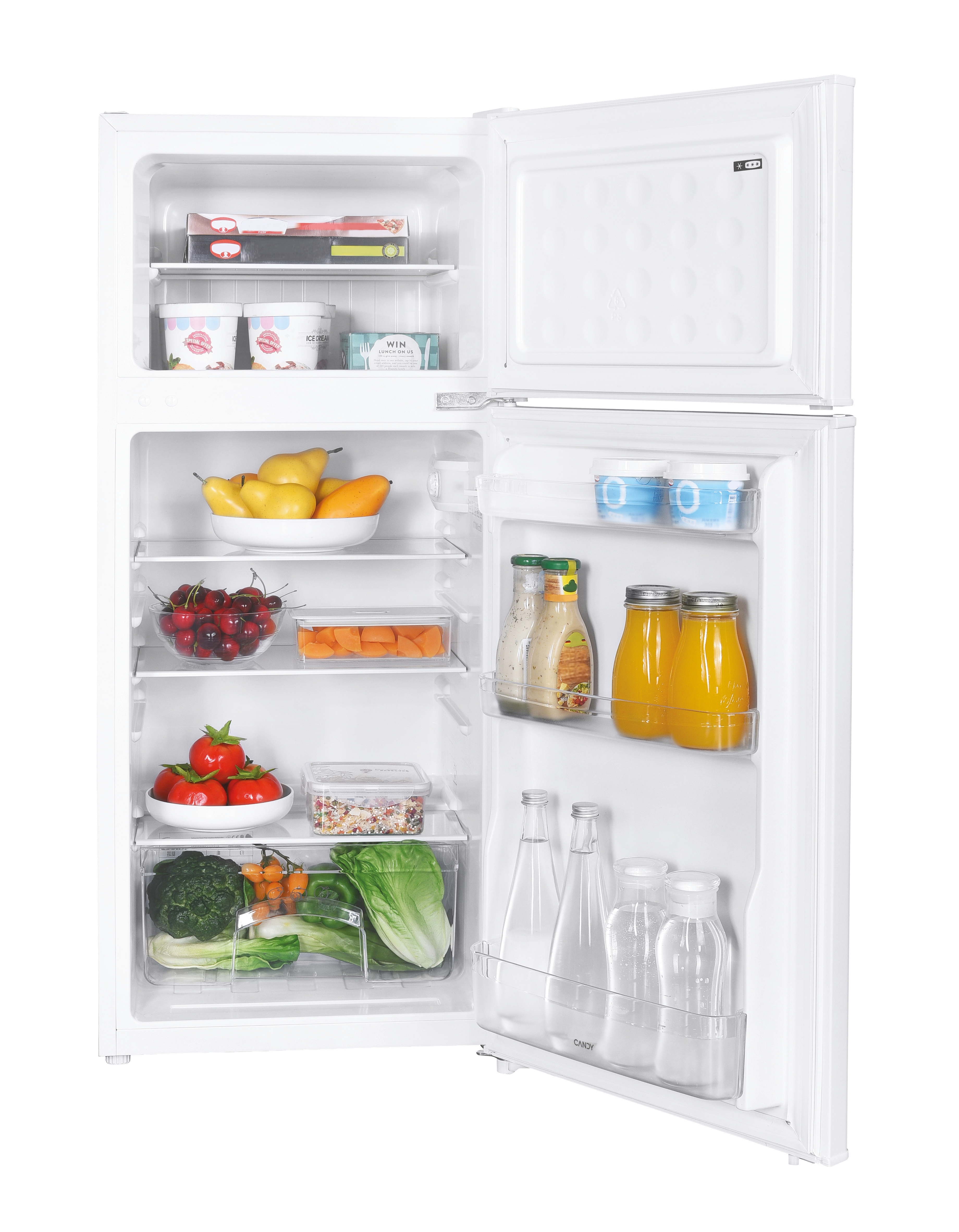 Frigorifero bianco aperto. All'interno, frutta, verdura, salse e gelato. Congelatore in alto. Logo Candy visibile.