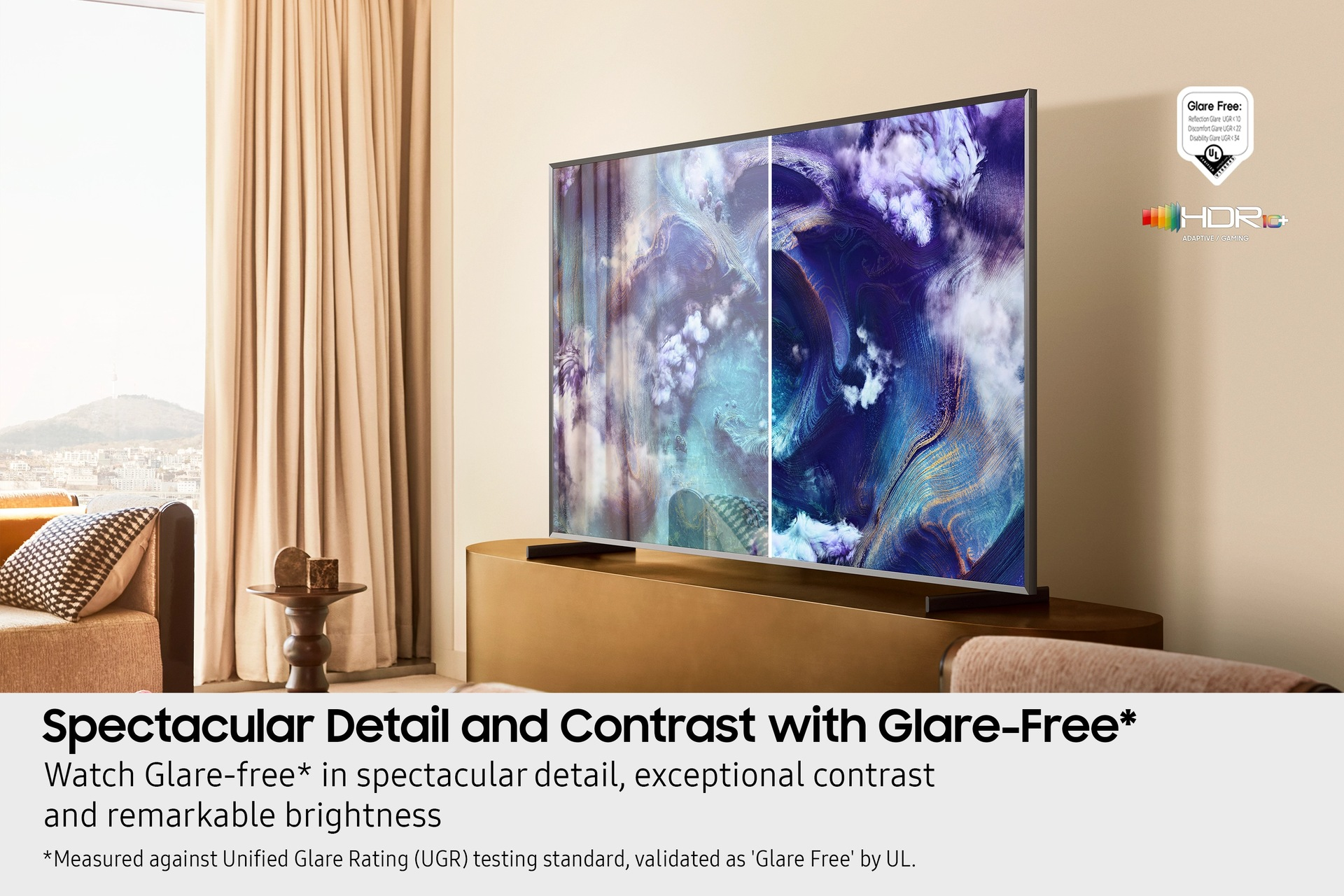 Un televisor grande muestra una imagen abstracta colorida. Está sobre un soporte dorado. A la izquierda, una ventana con cortinas.