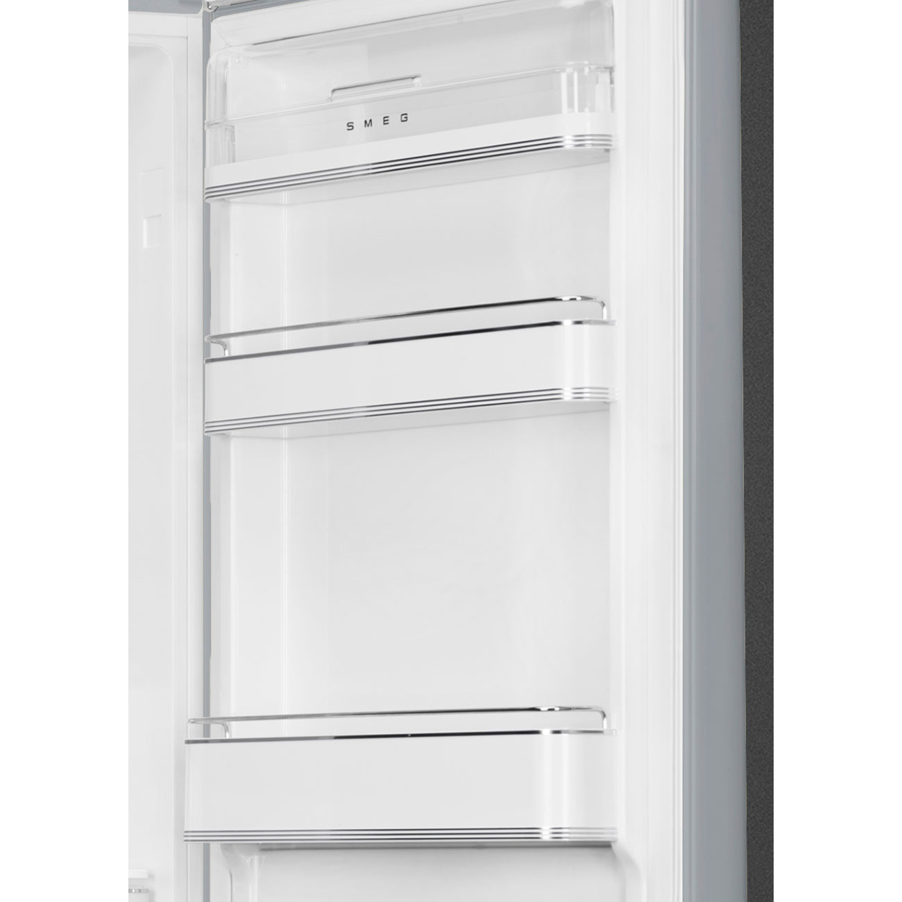 Interior de refrigerador blanco abierto con estantes. Se ve la marca SMEG. La puerta está parcialmente abierta mostrando el interior.