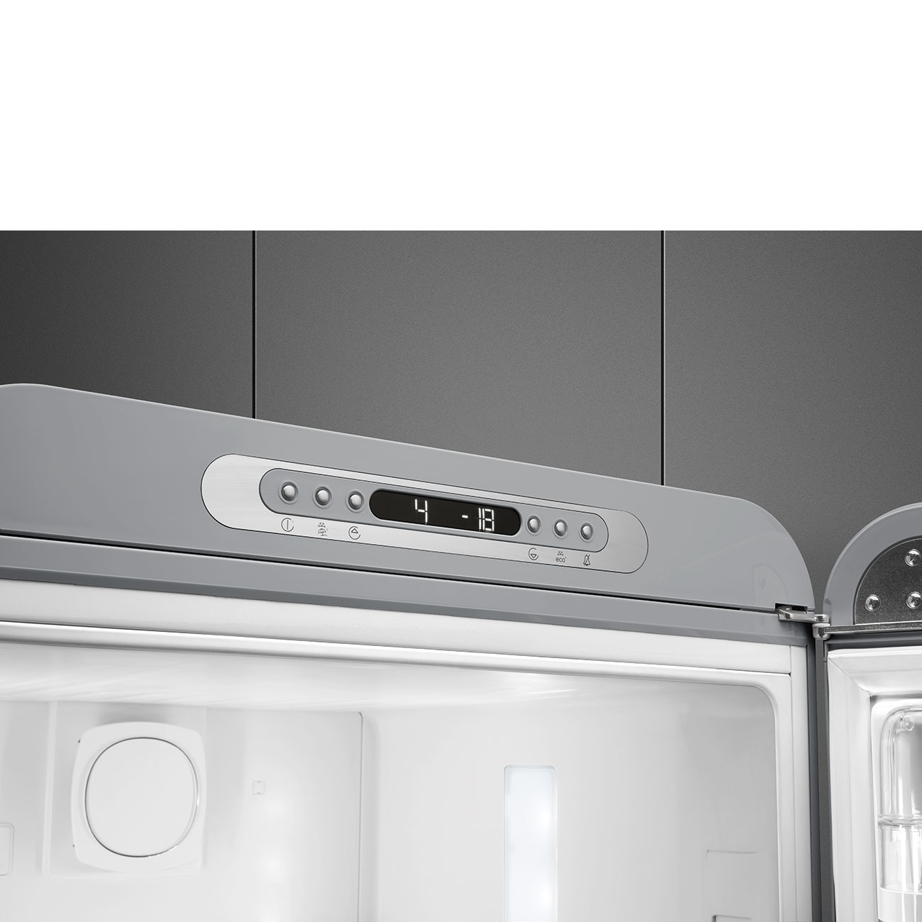 Primer plano del interior de un refrigerador. El panel de control muestra '4 - 18'. Interior blanco con luz y un componente circular blanco.