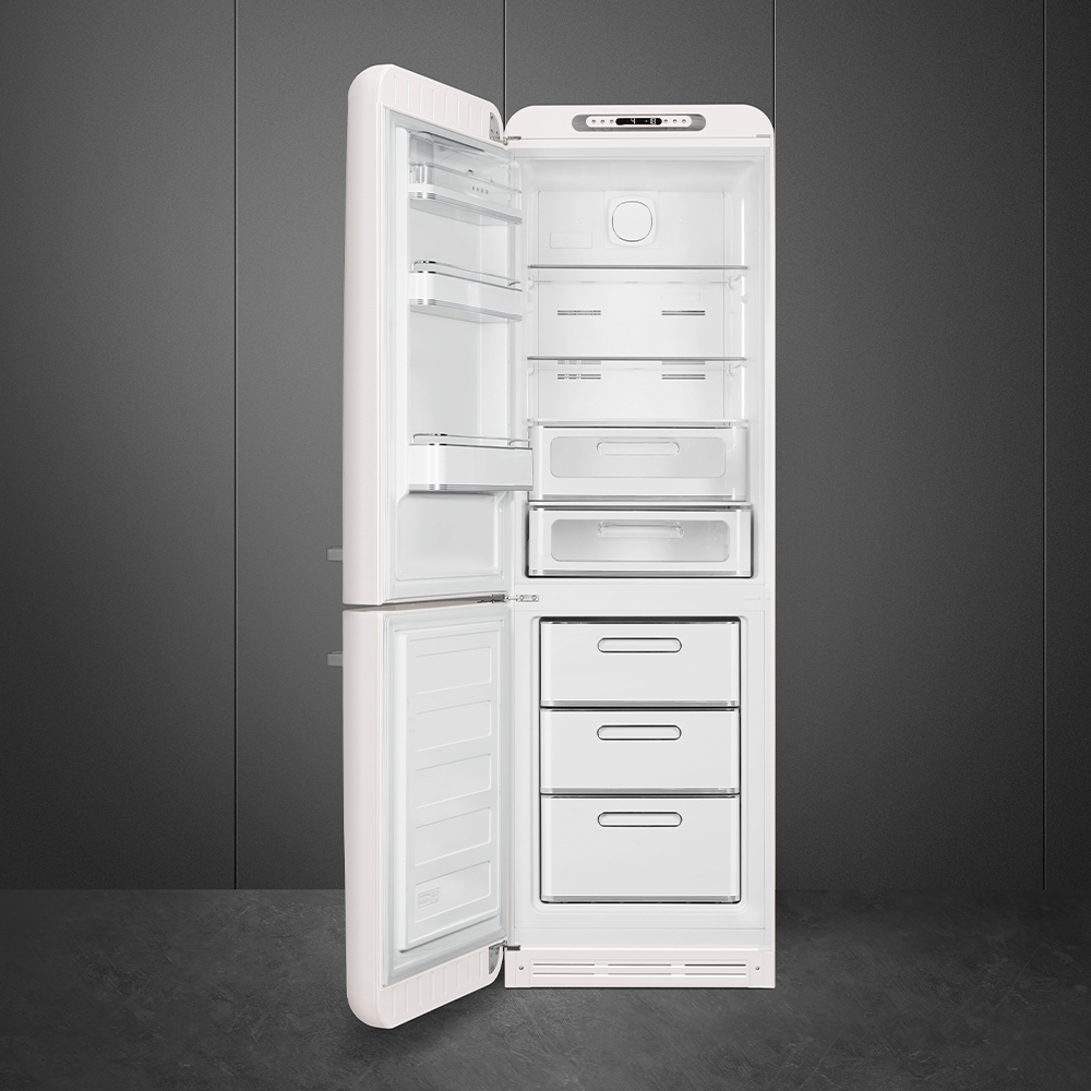 Ein weißer Retro-Kühlschrank mit offener Tür. Innen sind Regale, Schubladen und Fächer sichtbar. Der Hintergrund ist eine dunkelgraue Wand.