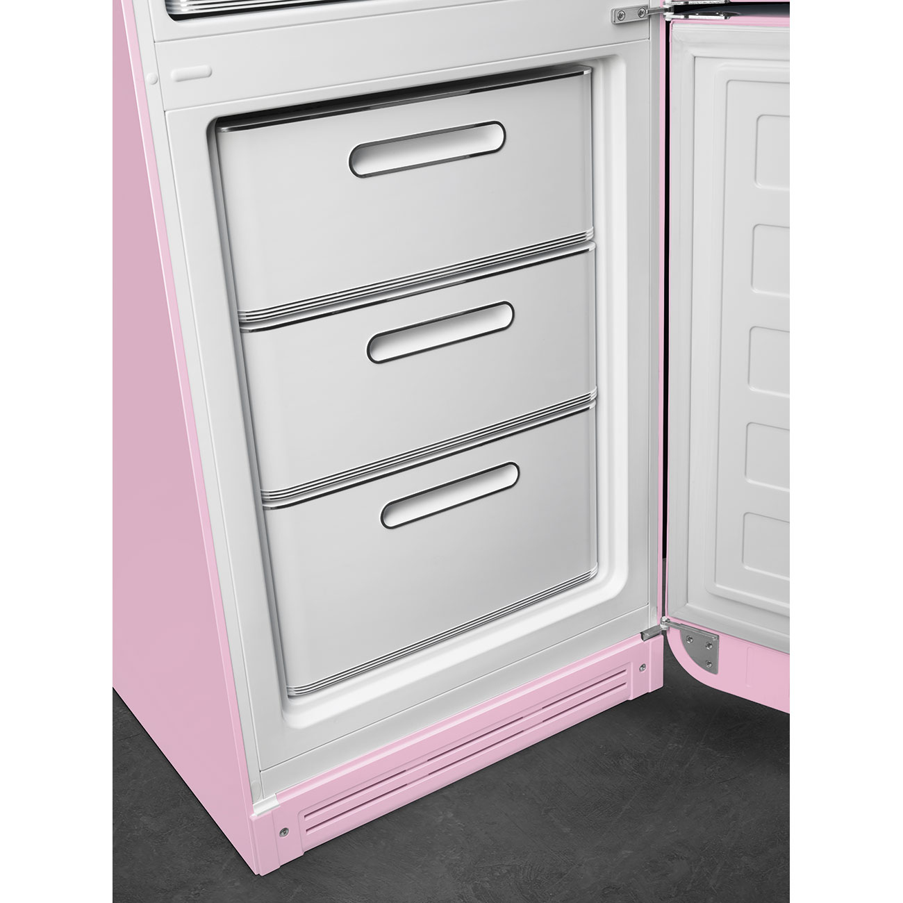 Un refrigerador rosa con la puerta abierta. En el interior hay tres cajones blancos. La puerta tiene un interior blanco.