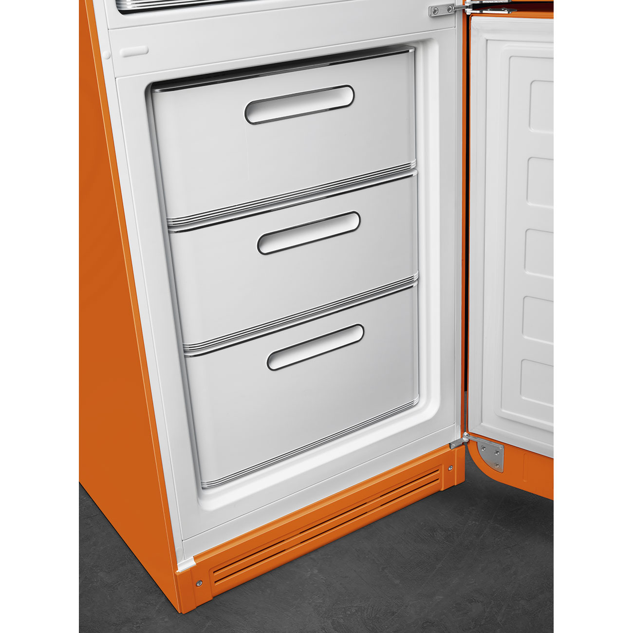 Ein orangefarbener Kühlschrank mit geöffneter Tür. Drei weiße Schubladen mit Griffen sind sichtbar. Innenraum und Tür sind weiß.