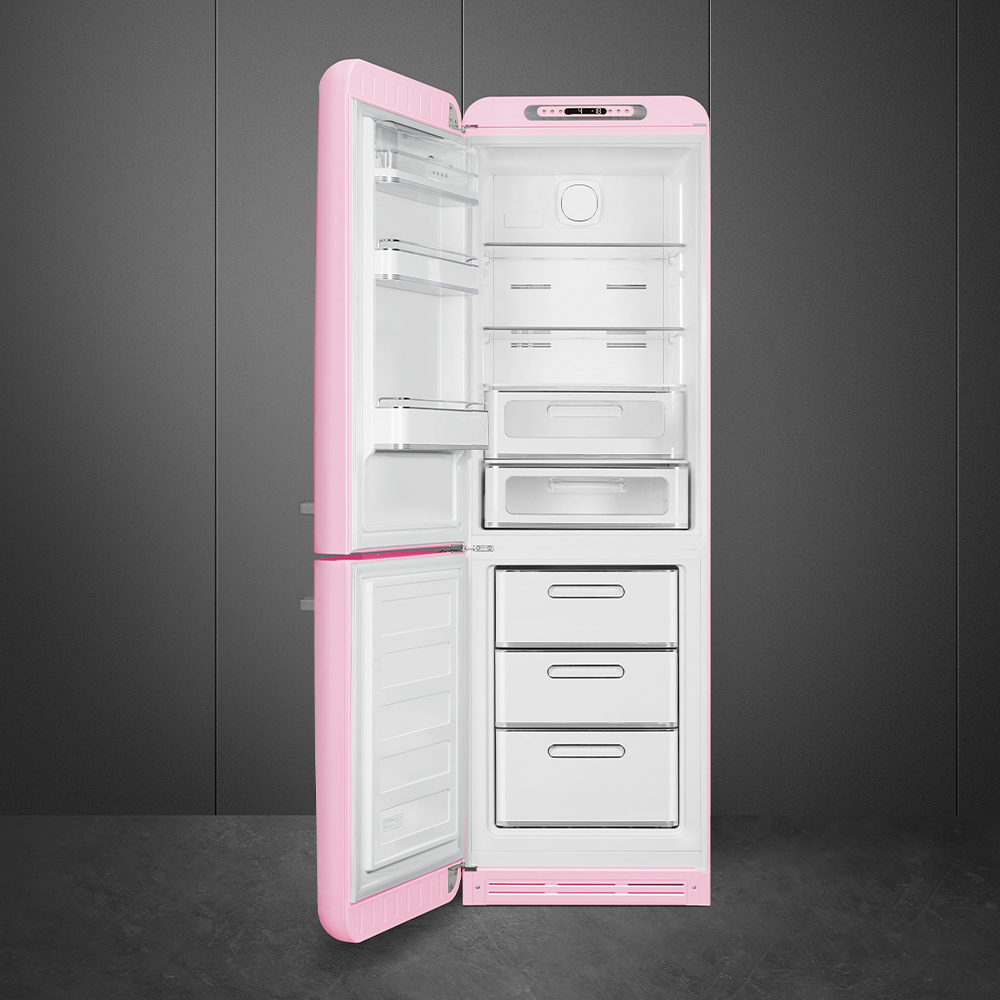 Un refrigerador rosa, con la puerta abierta, mostrando estantes, cajones e interior. Contra paredes y piso grises.