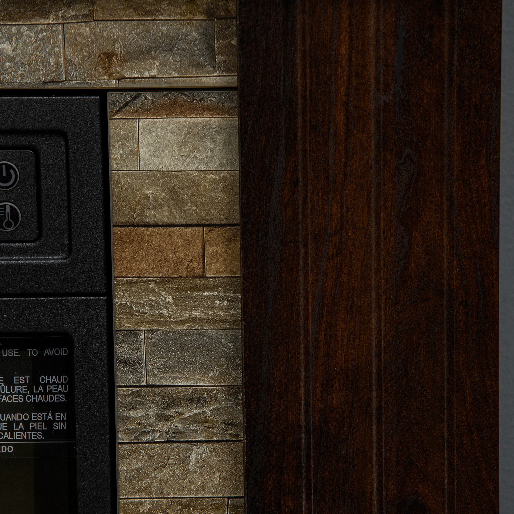 Primer plano de una chimenea eléctrica. Muestra ladrillo de piedra, panel de madera oscura y panel de control con texto en francés y español.