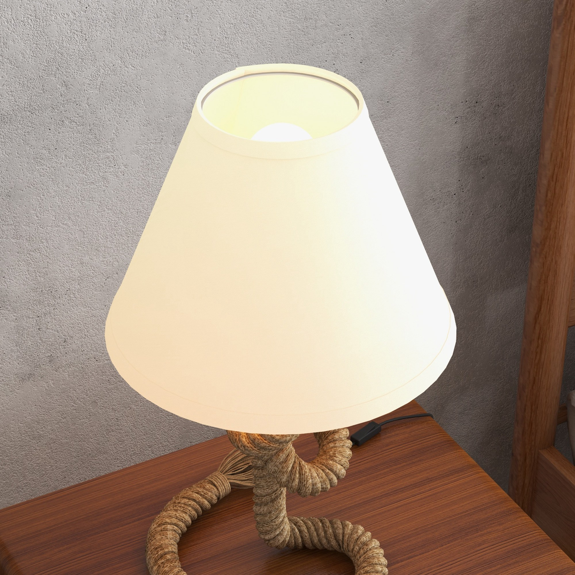 Una lámpara beige con base de cuerda está sobre una mesa de madera. Un muro gris texturizado está al fondo.