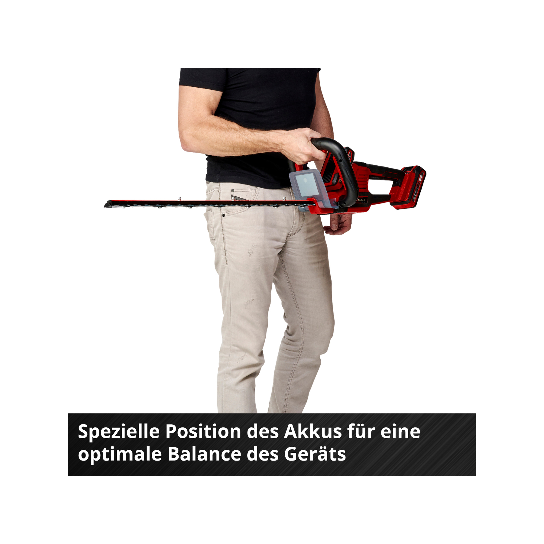 Mężczyzna trzyma czerwono-czarne nożyce do żywopłotu. Tekst poniżej: Specjalna pozycja baterii dla optymalnej równowagi urządzenia.