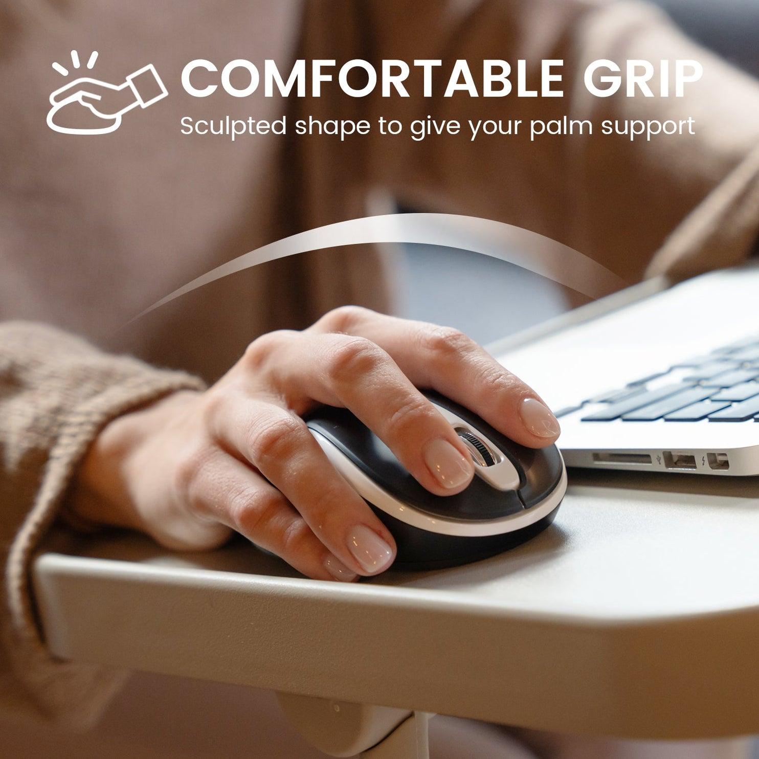 Ręka używa czarno-srebrnej myszy komputerowej na biurku. Mysz znajduje się w pobliżu laptopa. Tekst brzmi: 'Wygodny uchwyt'.
