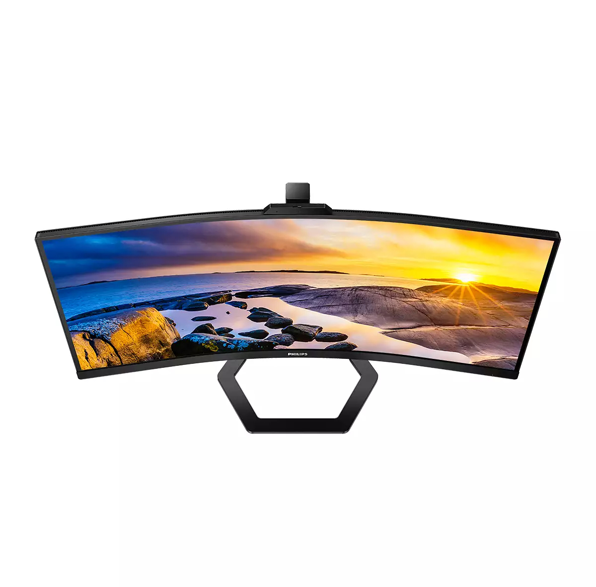 Gekrümmter Monitor mit Sonnenuntergangslandschaft. Der Monitor hat einen schwarzen Rahmen und Ständer. Der Bildschirm zeigt Felsen und Wasser.