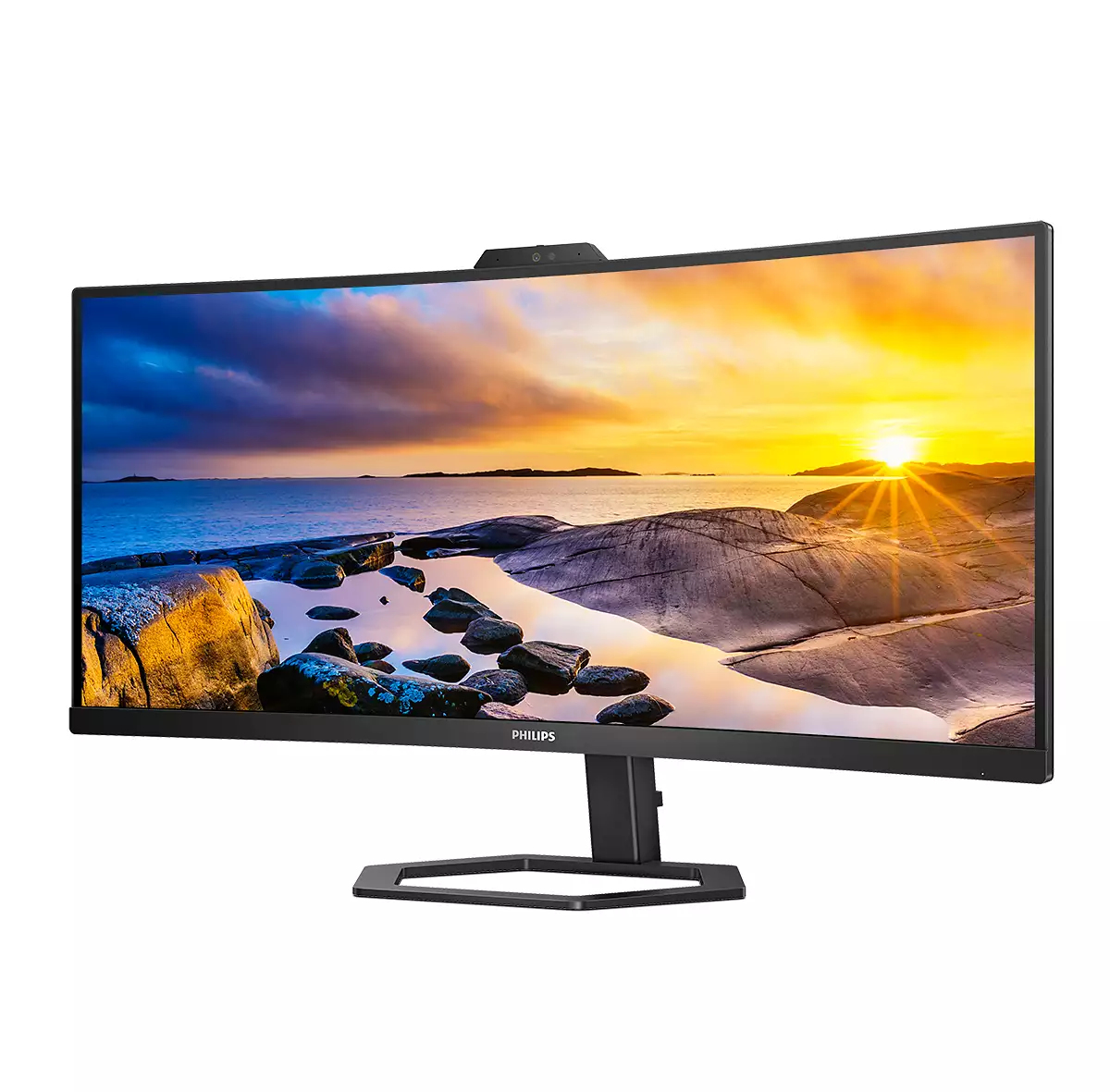 Ein geschwungener Philips-Monitor zeigt einen Sonnenuntergang über Wasser und Felsen. Eine Kamera befindet sich über dem Bildschirm.