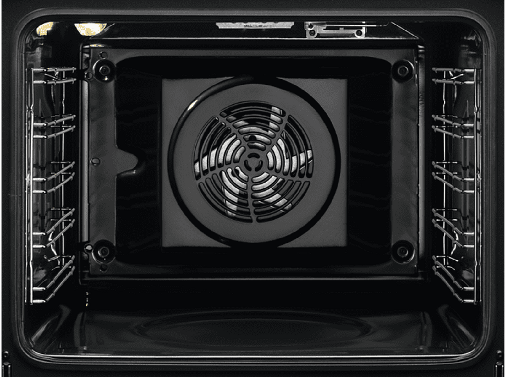 Interno di un forno nero. Al centro c'è una ventola. Griglie metalliche su entrambi i lati. Sono visibili quattro viti.