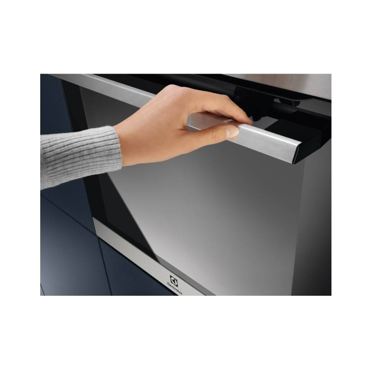 Una mano tira la maniglia argentata del forno. Il forno è nero e argento, con un telaio blu-grigio. Il marchio Electrolux è visibile.