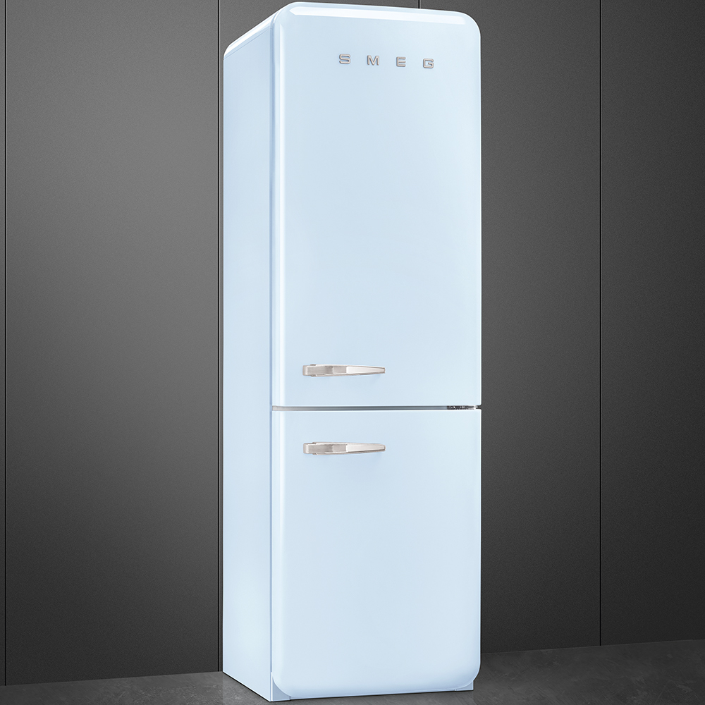 Un refrigerador Smeg celeste claro se encuentra contra una pared gris. Tiene manijas plateadas y la marca arriba.