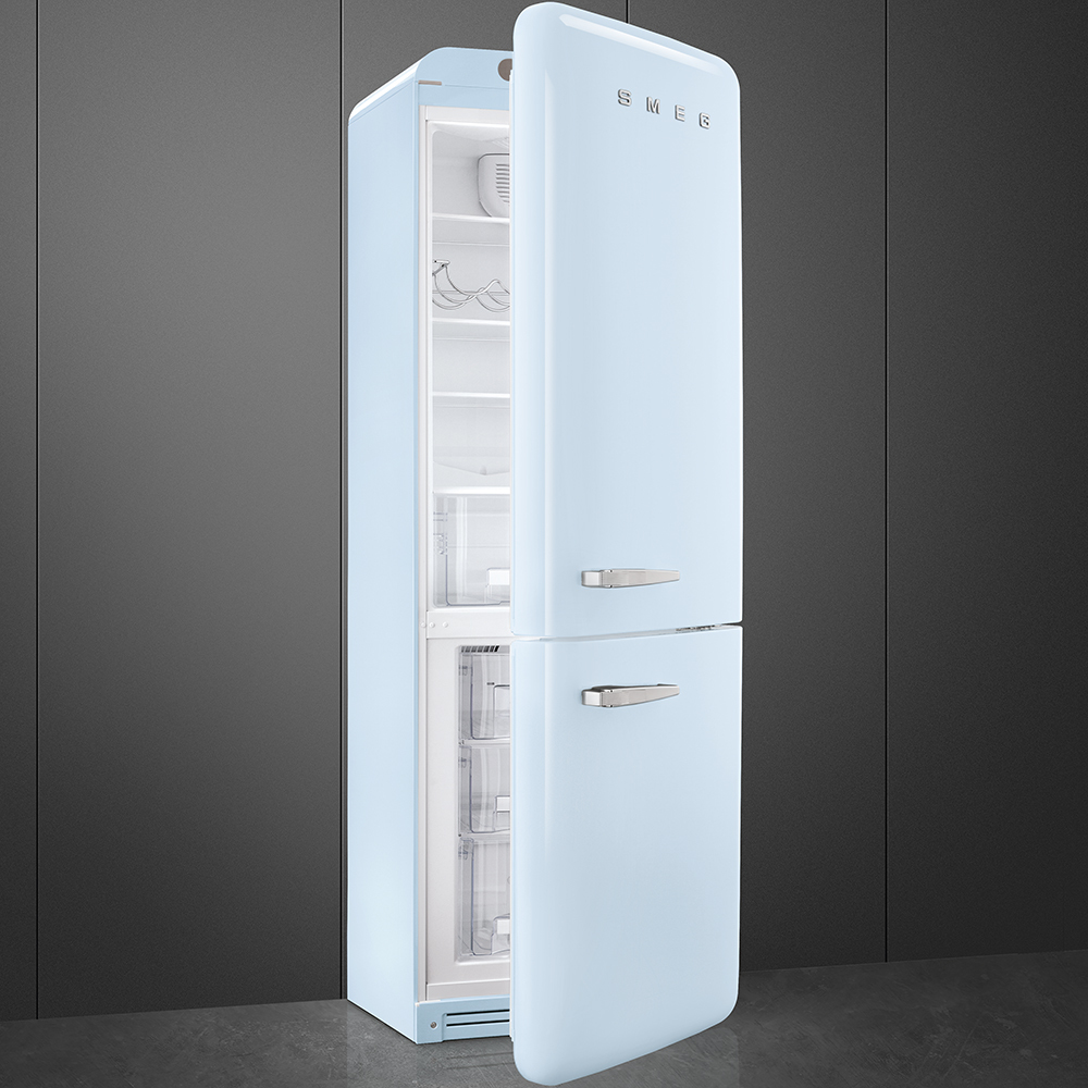 Un refrigerador Smeg azul claro con la puerta entreabierta, revelando estantes interiores. Se encuentra contra un fondo gris y negro.