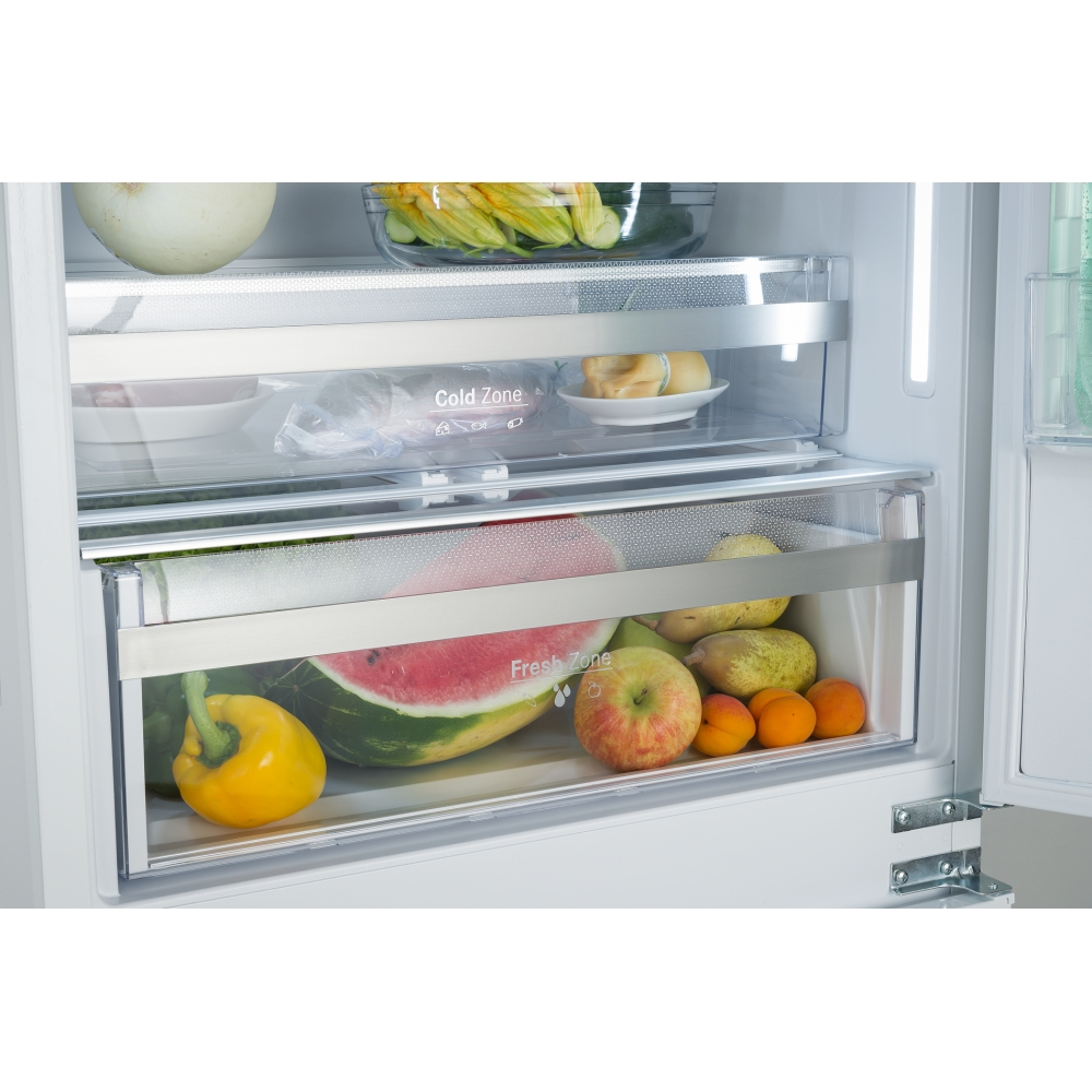 All'interno di un frigorifero: anguria, mela, peperone, albicocche e altri frutti e verdure sono conservati in cassetti e ripiani.