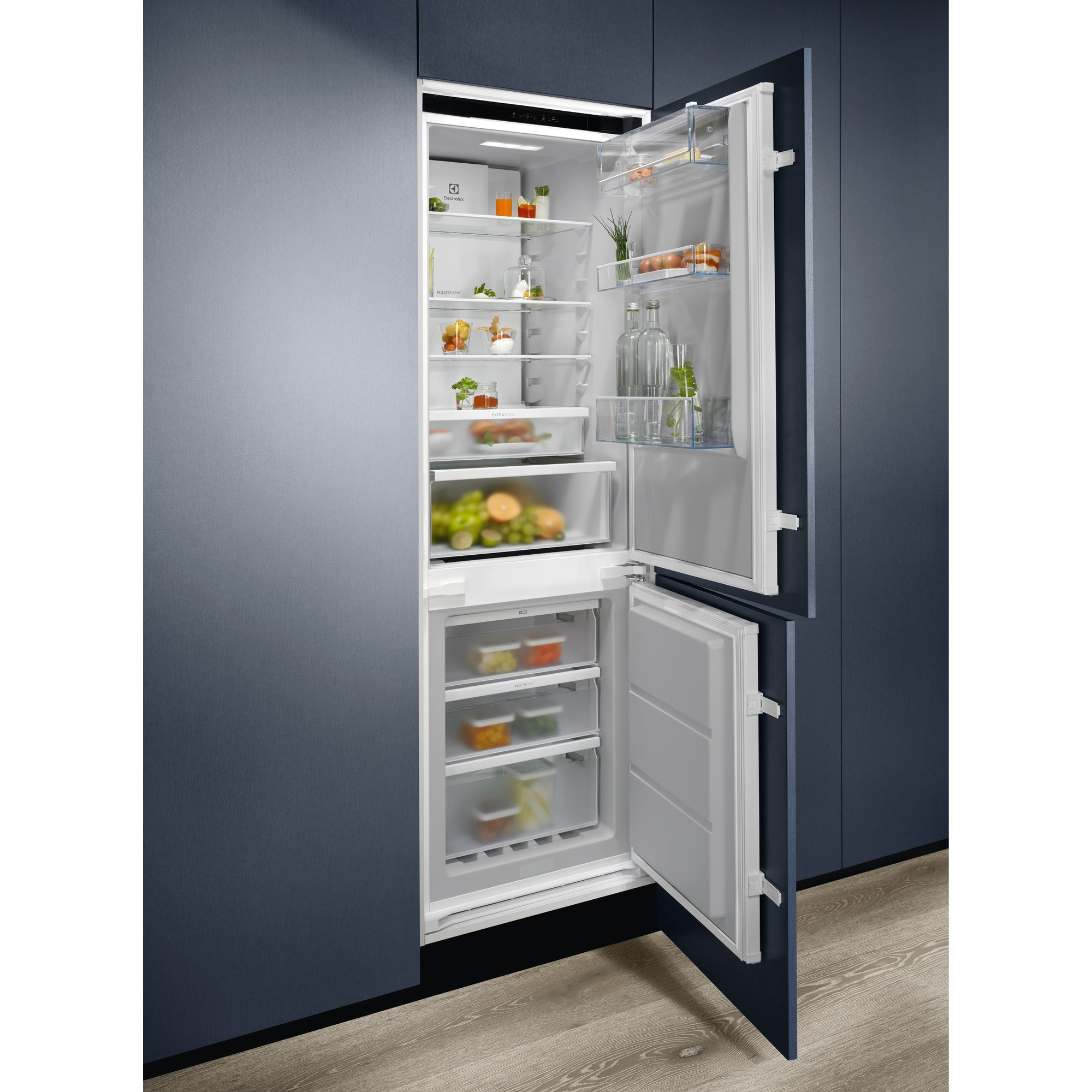 Un refrigerador abierto muestra alimentos en compartimentos. El refrigerador es blanco por dentro, azul oscuro por fuera.