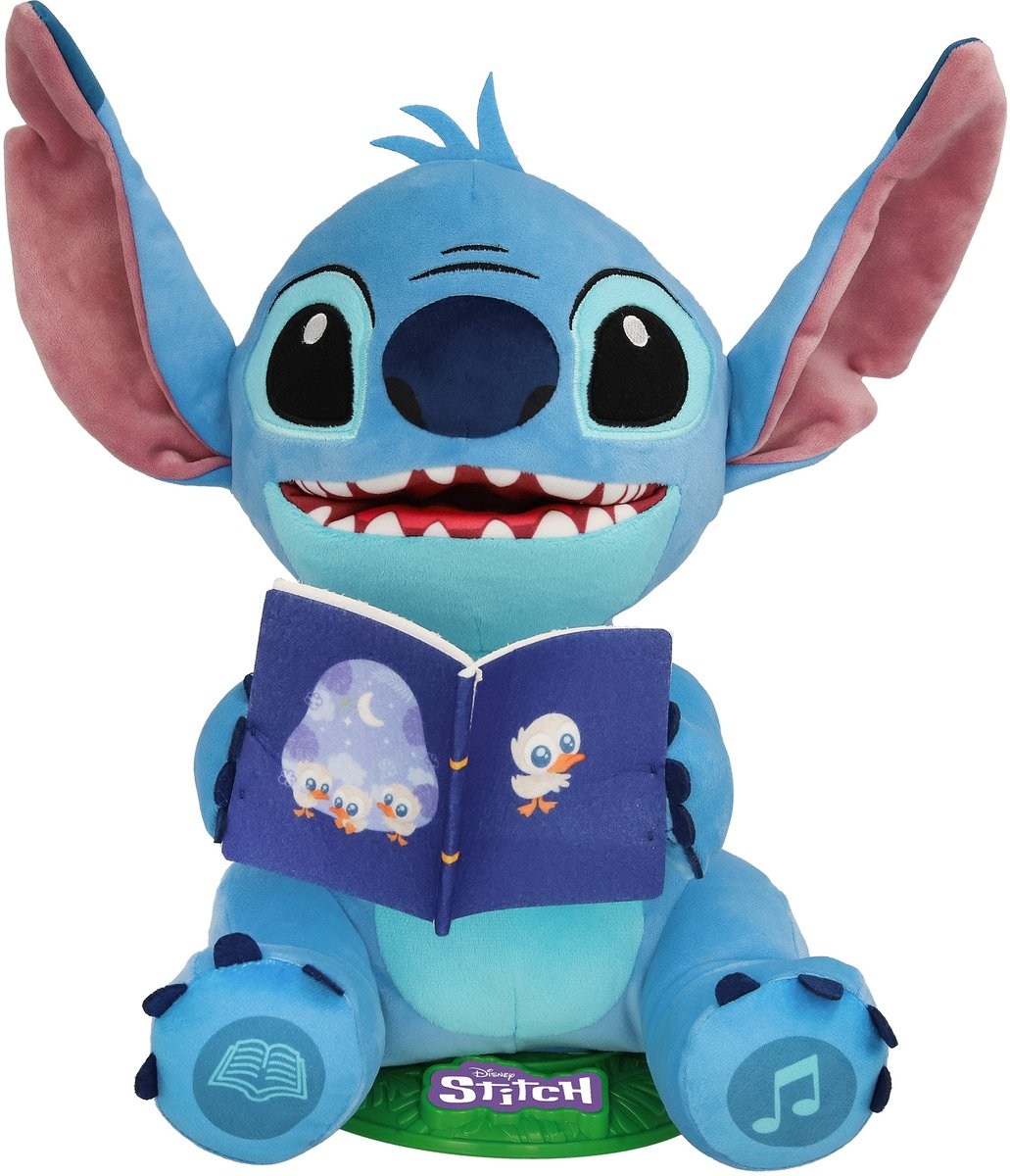 Ein Stitch-Plüschtier liest ein Buch. Es ist blau mit großen Ohren, hält ein offenes Buch mit Illustrationen und sitzt auf einer grünen Basis.