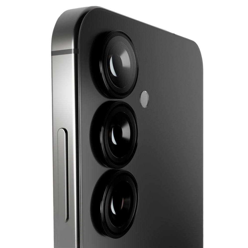 Zbliżenie tyłu czarnego smartfona z trzema obiektywami aparatu. Srebrna ramka z boku. Białe tło.