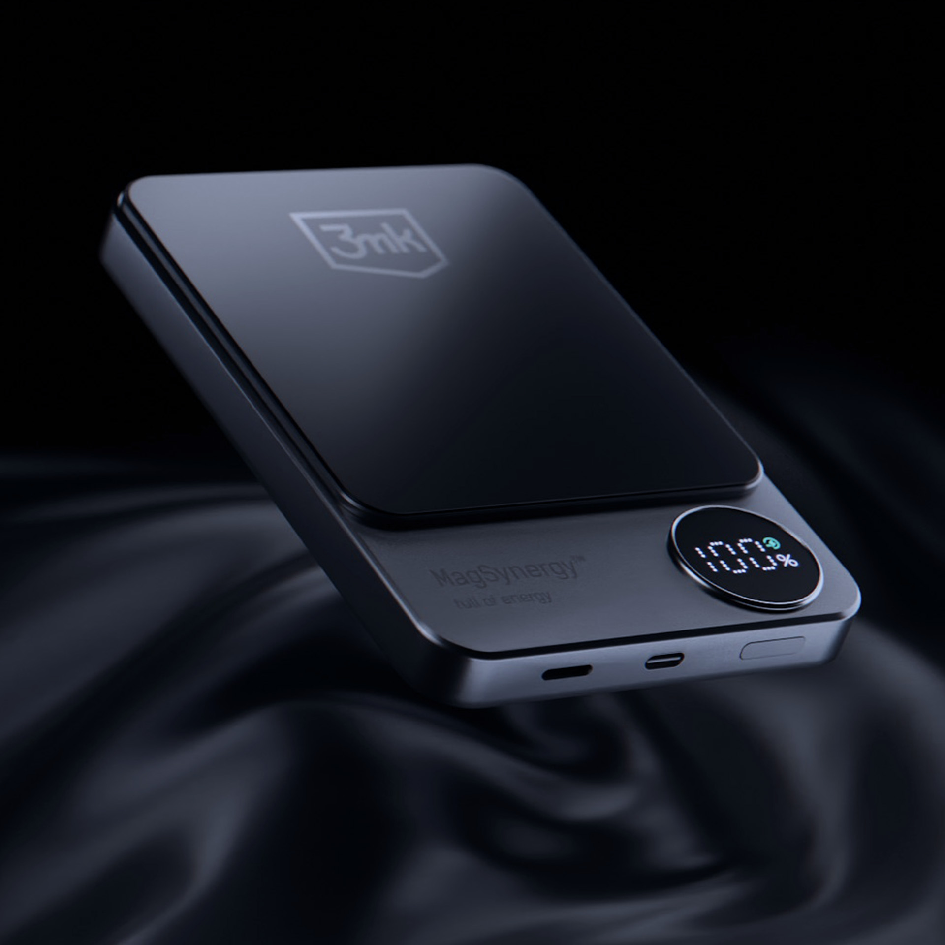 Czarny power bank z ekranem pokazującym 100%. Ma logo i tekst "MagSynergy full of energy".