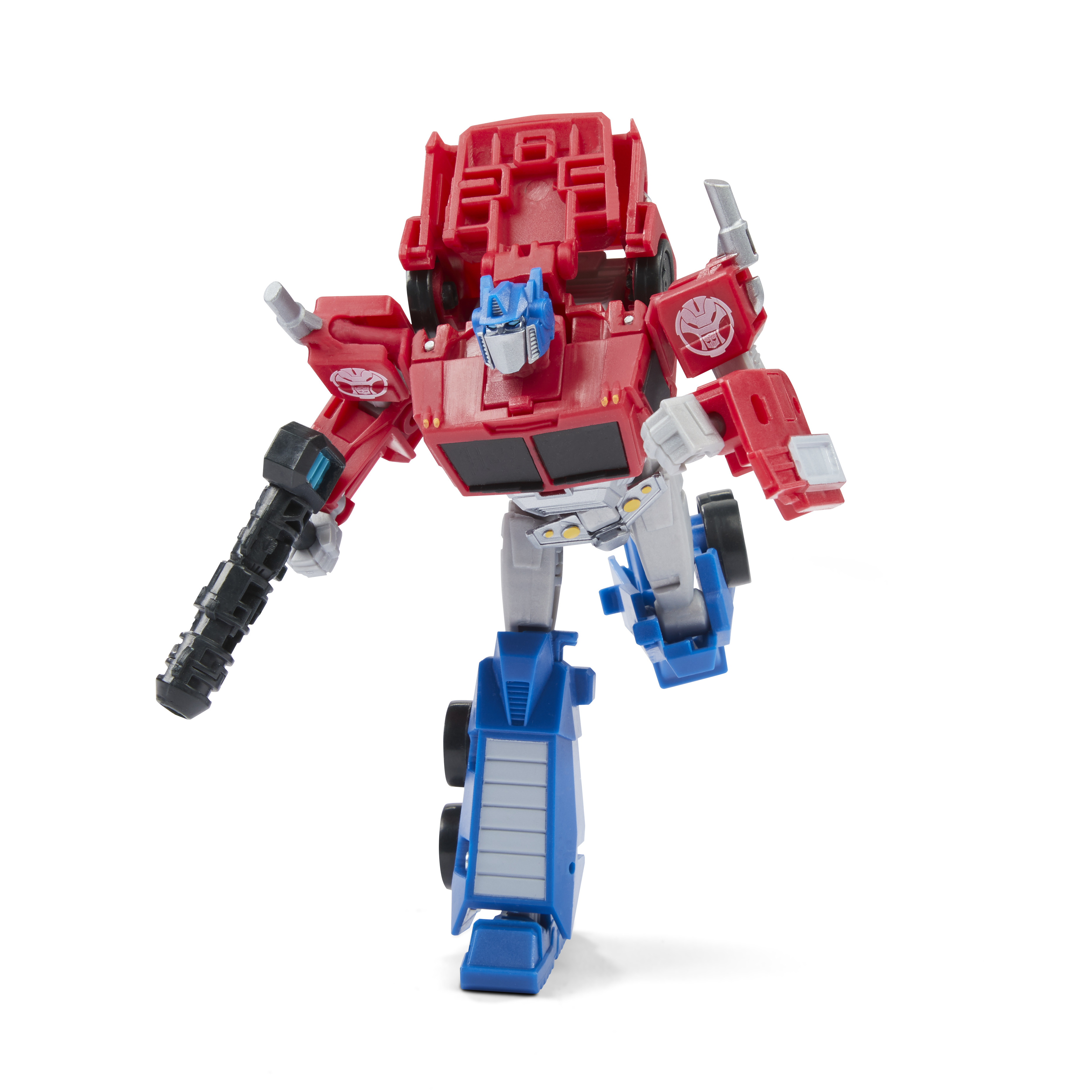 Un juguete Transformer rojo, azul y gris posa dinámicamente sobre un fondo blanco. Tiene una pistola y está a medio paso.