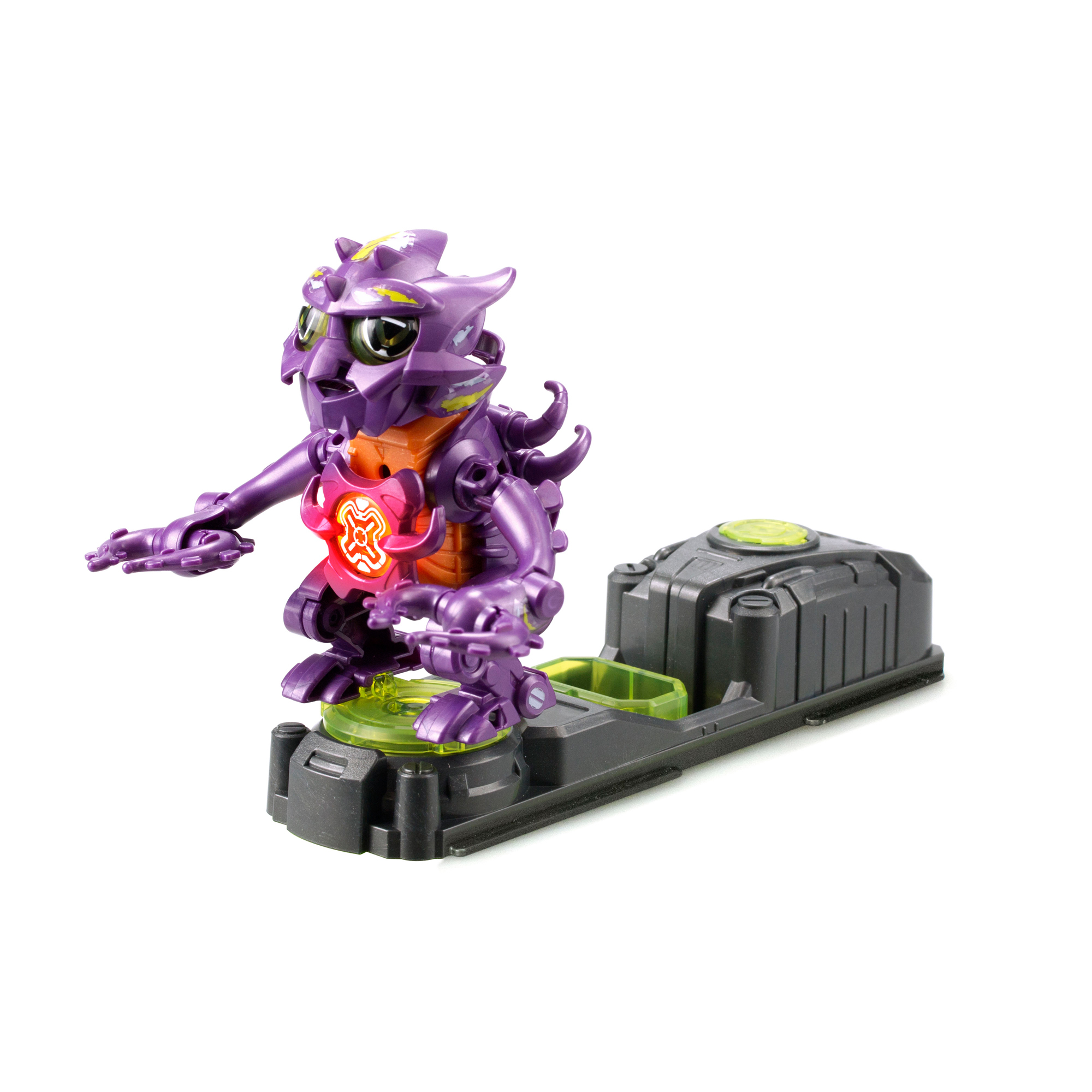 Fioletowa zabawka robota stoi na czarnej podstawie. Ma pomarańczowy środek i świecącą czerwoną pierś. Jest na białym tle.